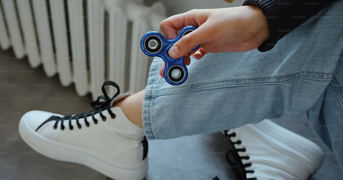 Person holding a blue fidget spinner toy photo – Woman Image on Unsplash