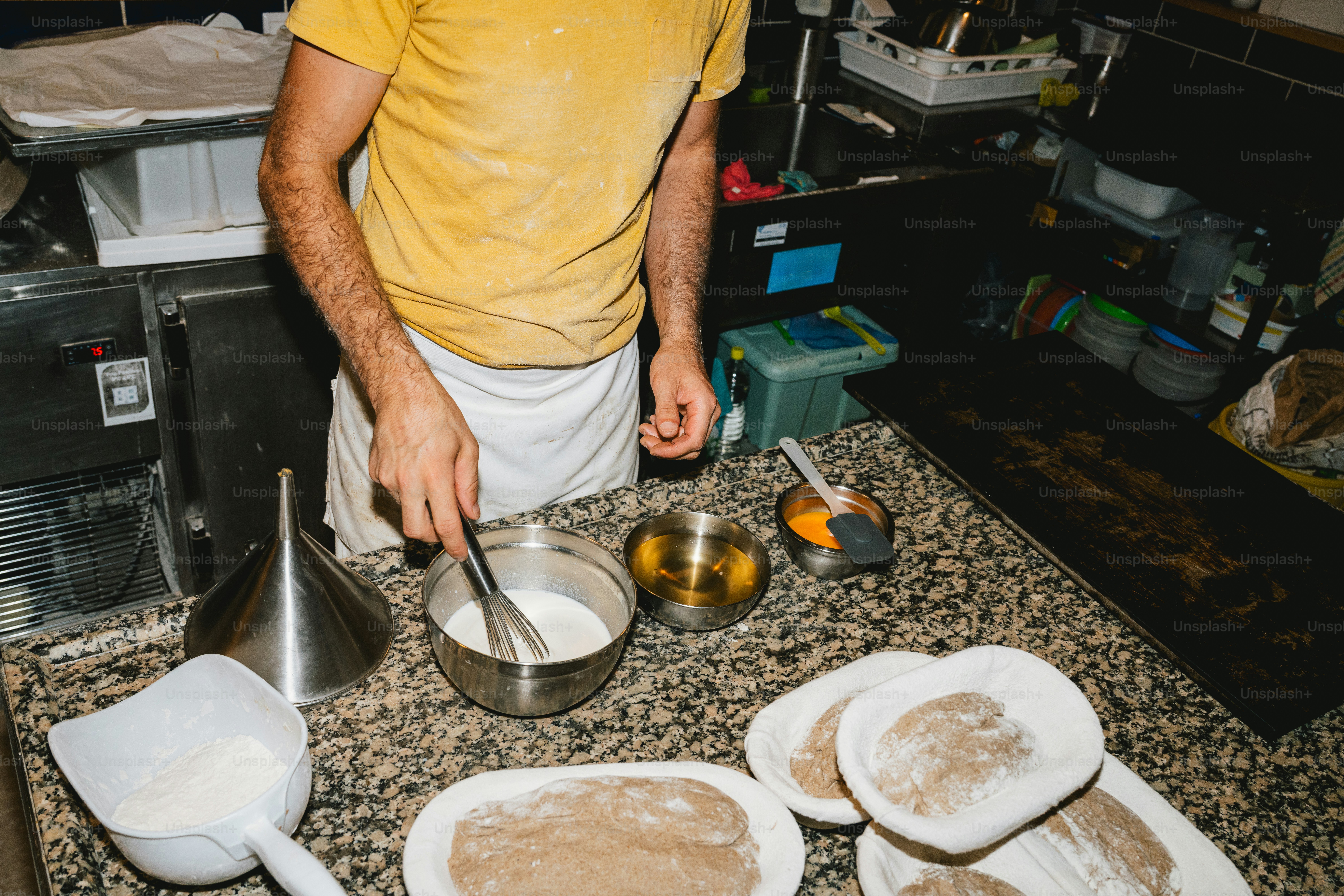 Chef whisking ingredients in a metal bowl