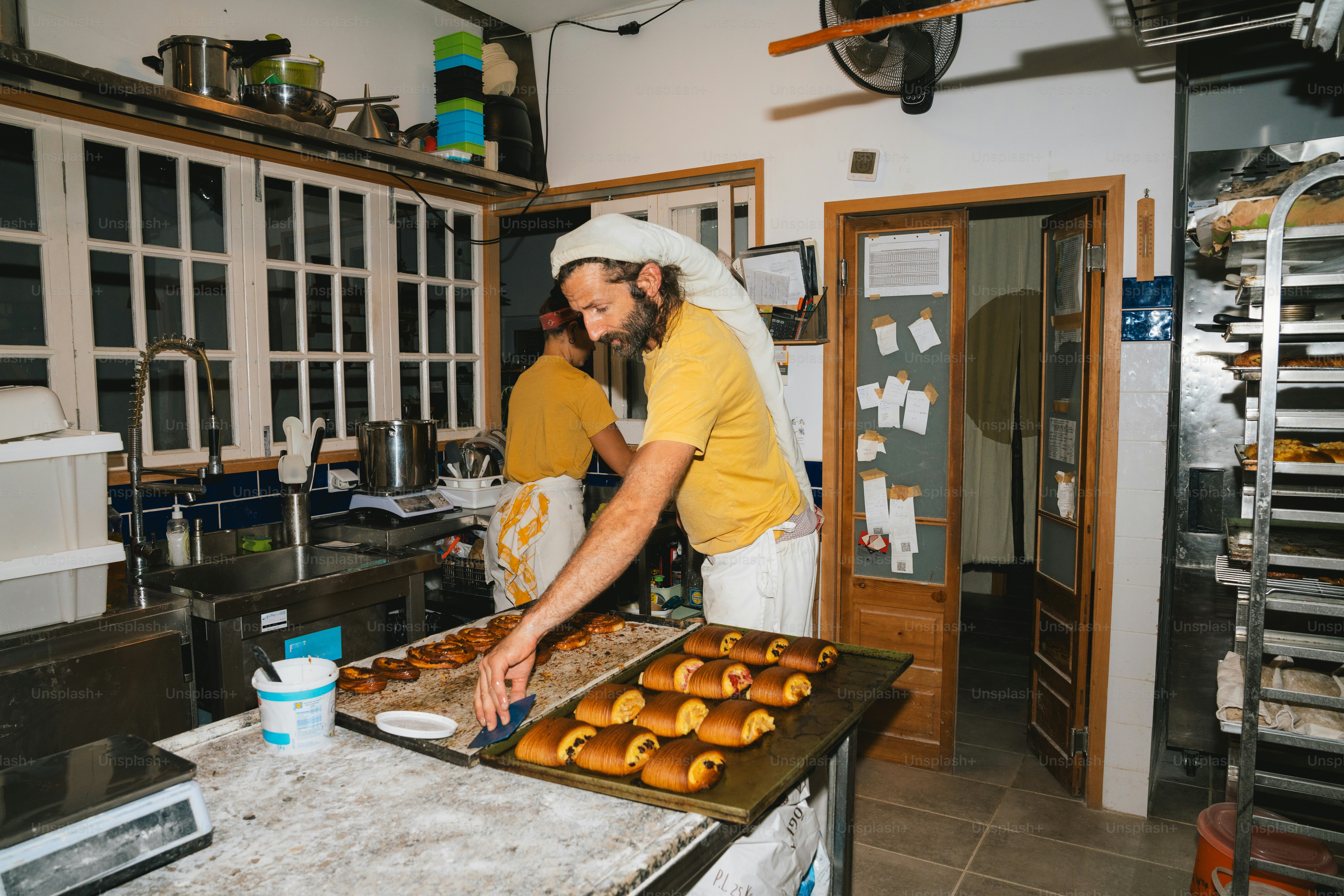 Baker covered in dough works in a kitchen. photo – Bakery Image on Unsplash
