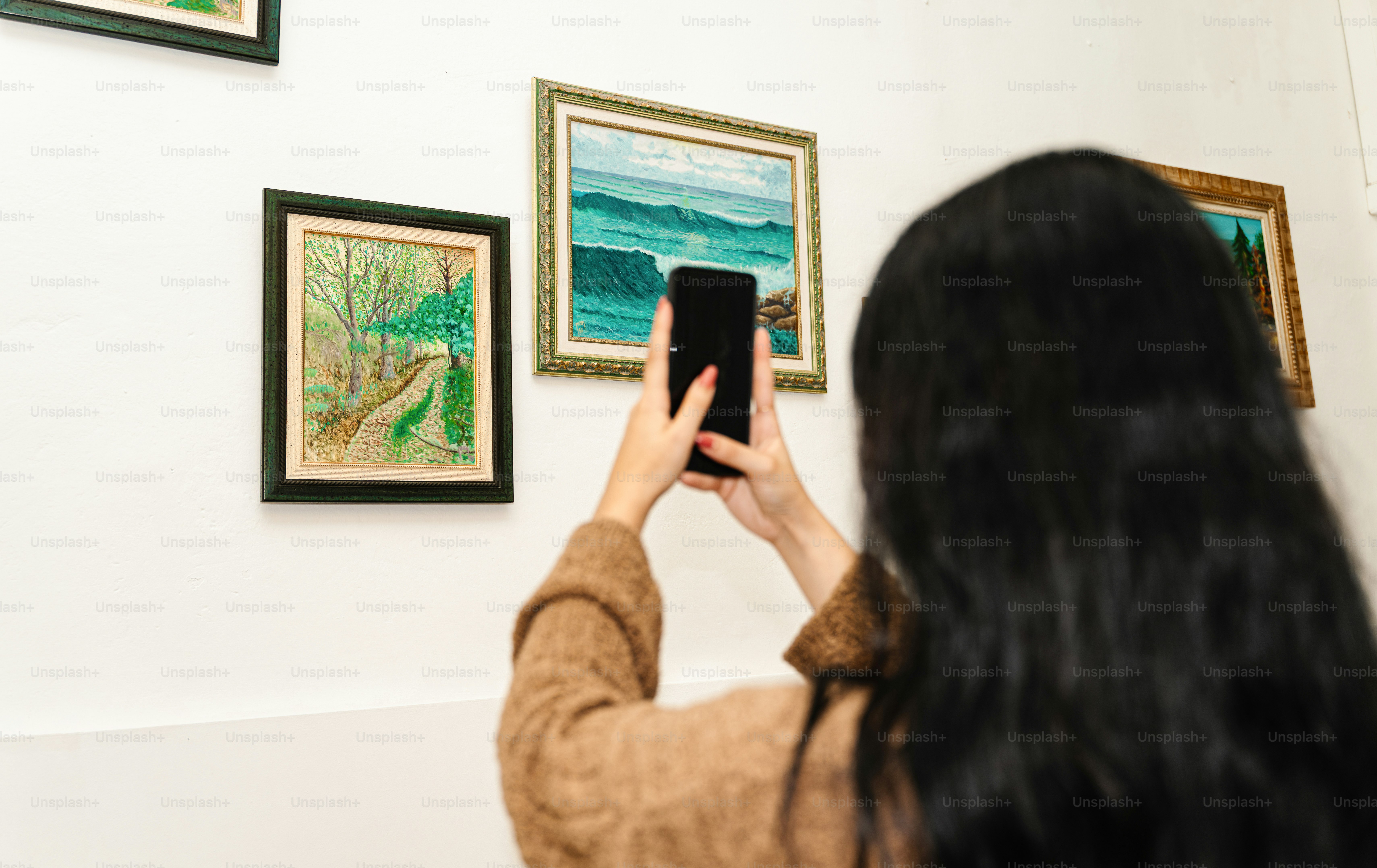 Woman takes a picture of art with phone