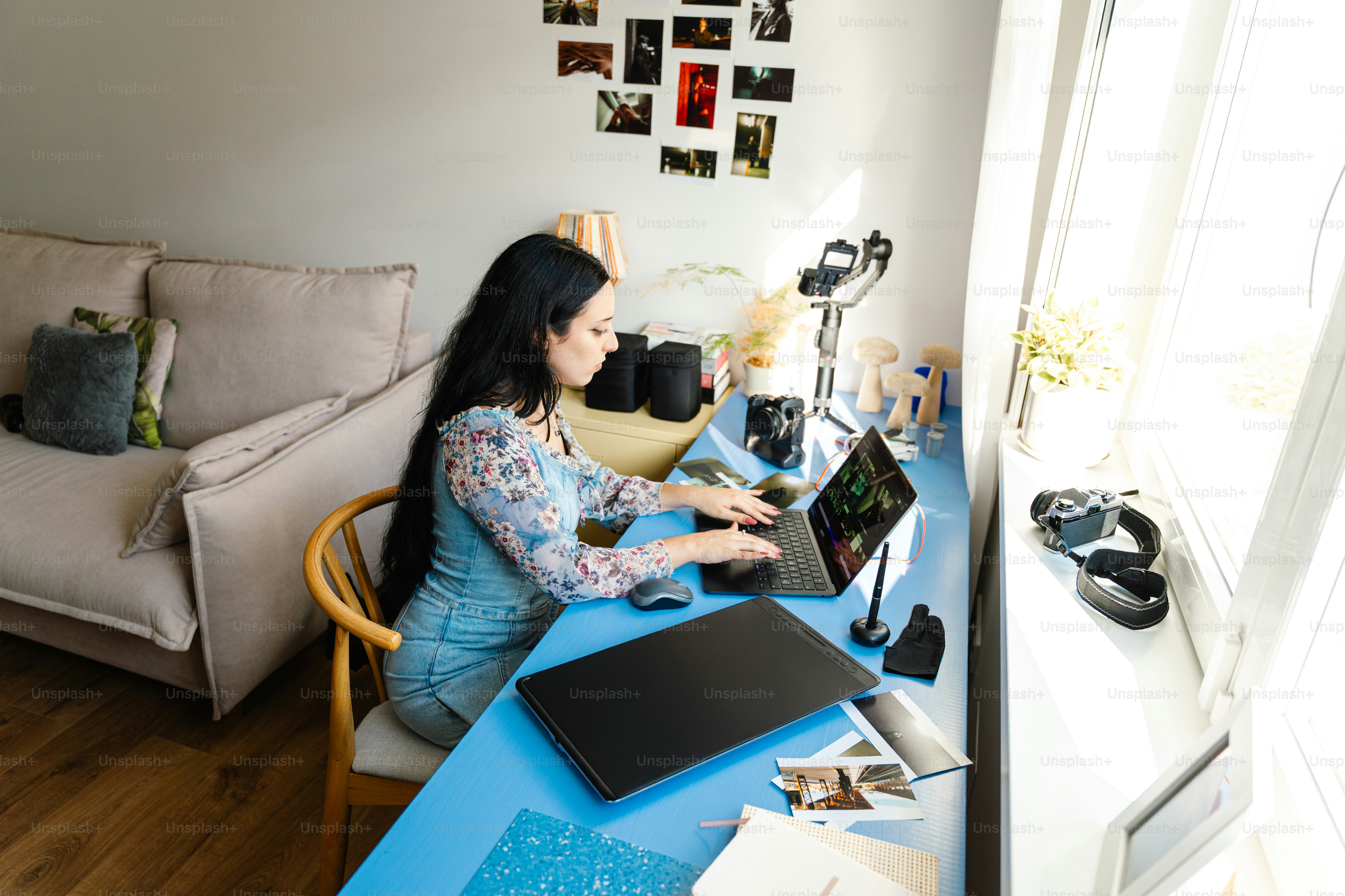 Woman working on laptop at a bright desk.