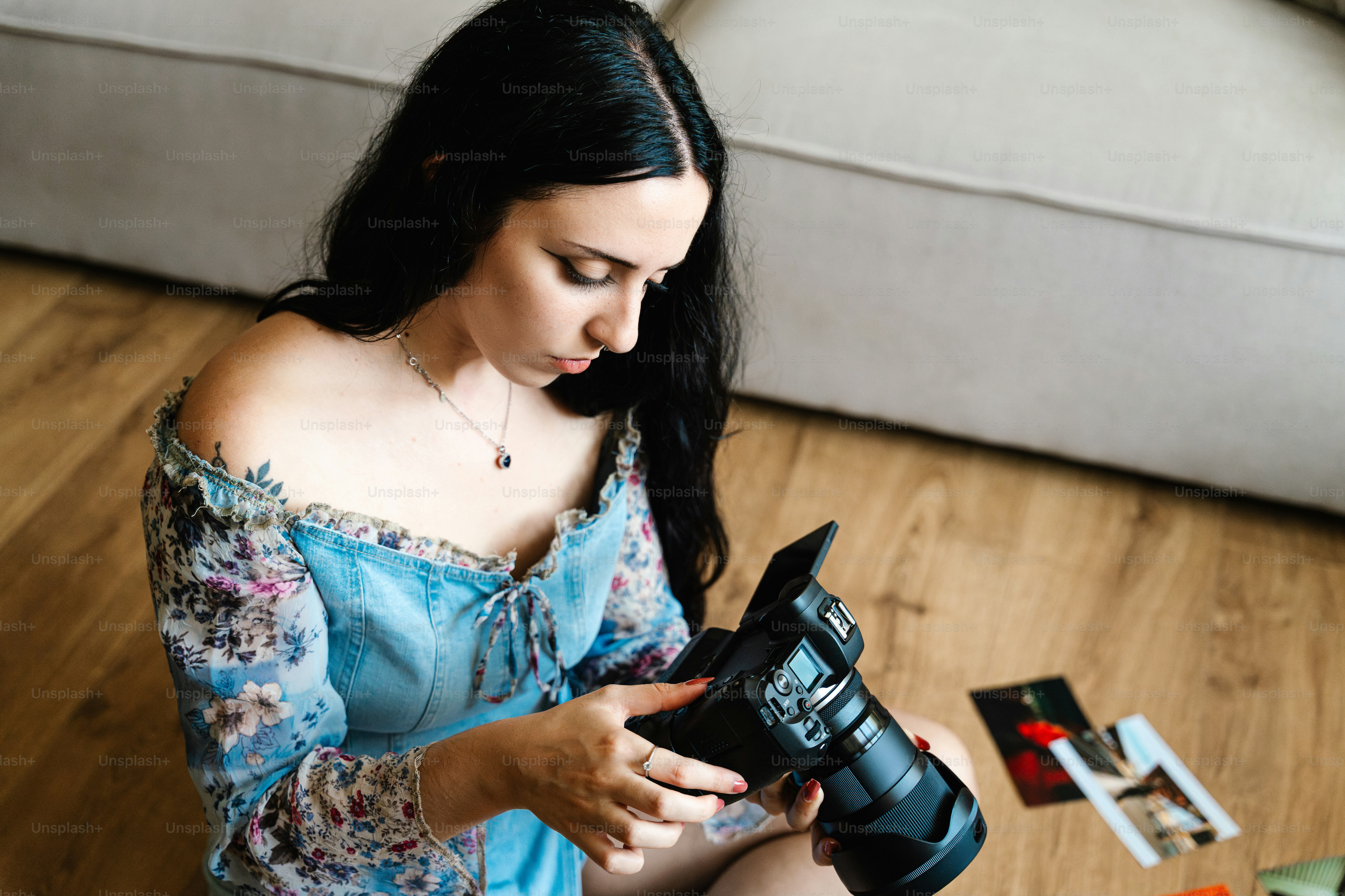 Woman with camera sitting on wooden floor