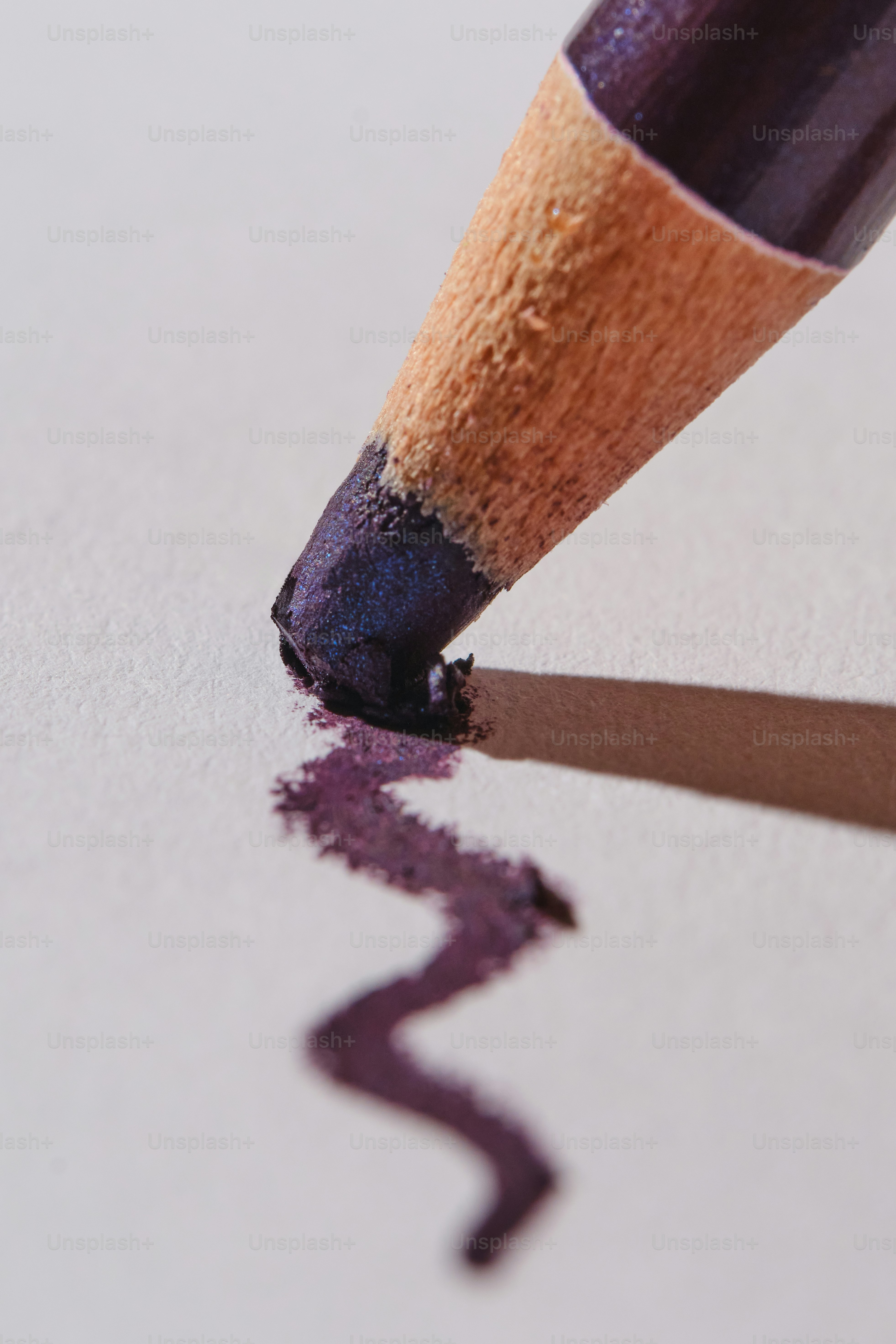 Purple eyeliner pencil drawing a wavy line.