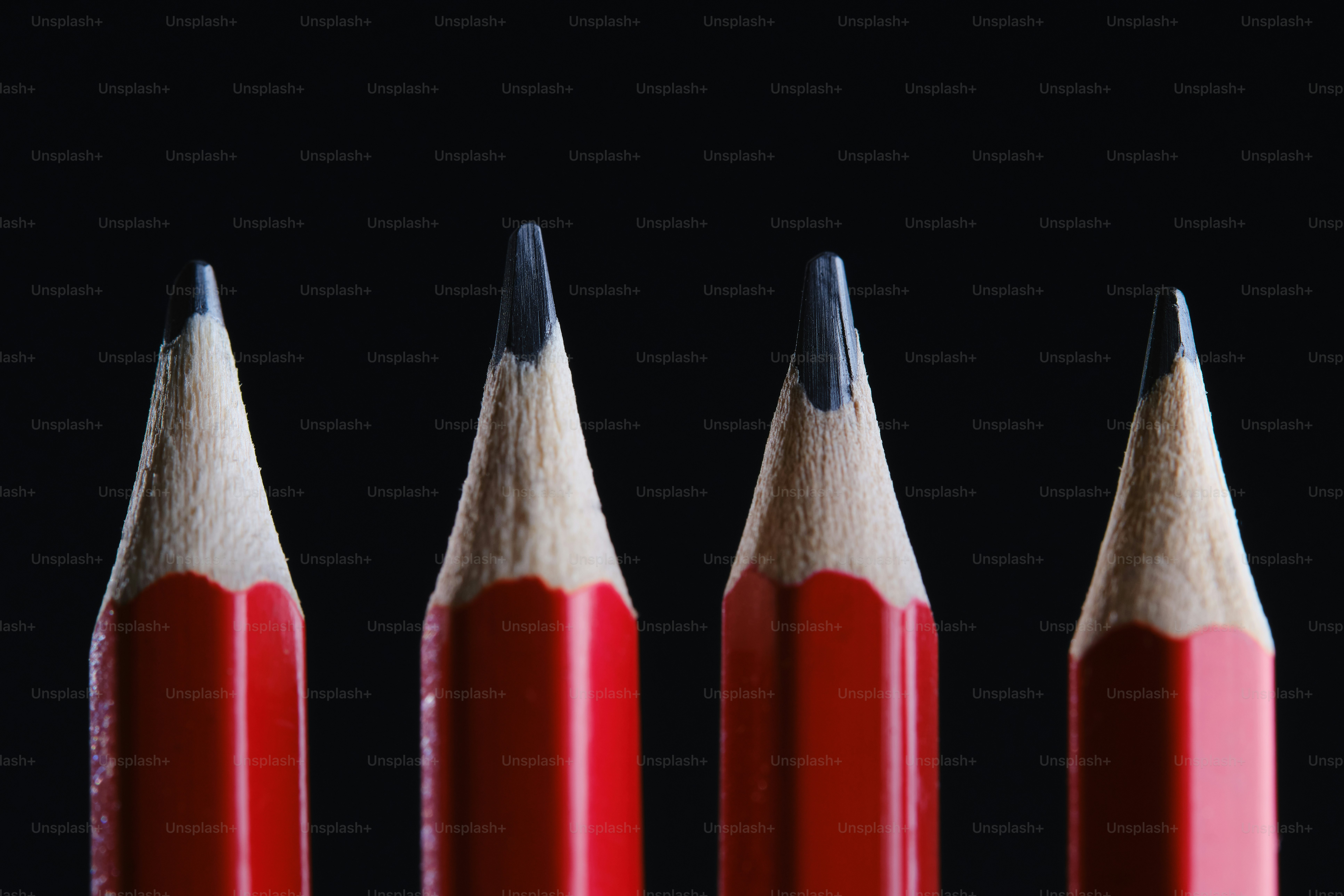 Four sharpened red pencils lined up closely