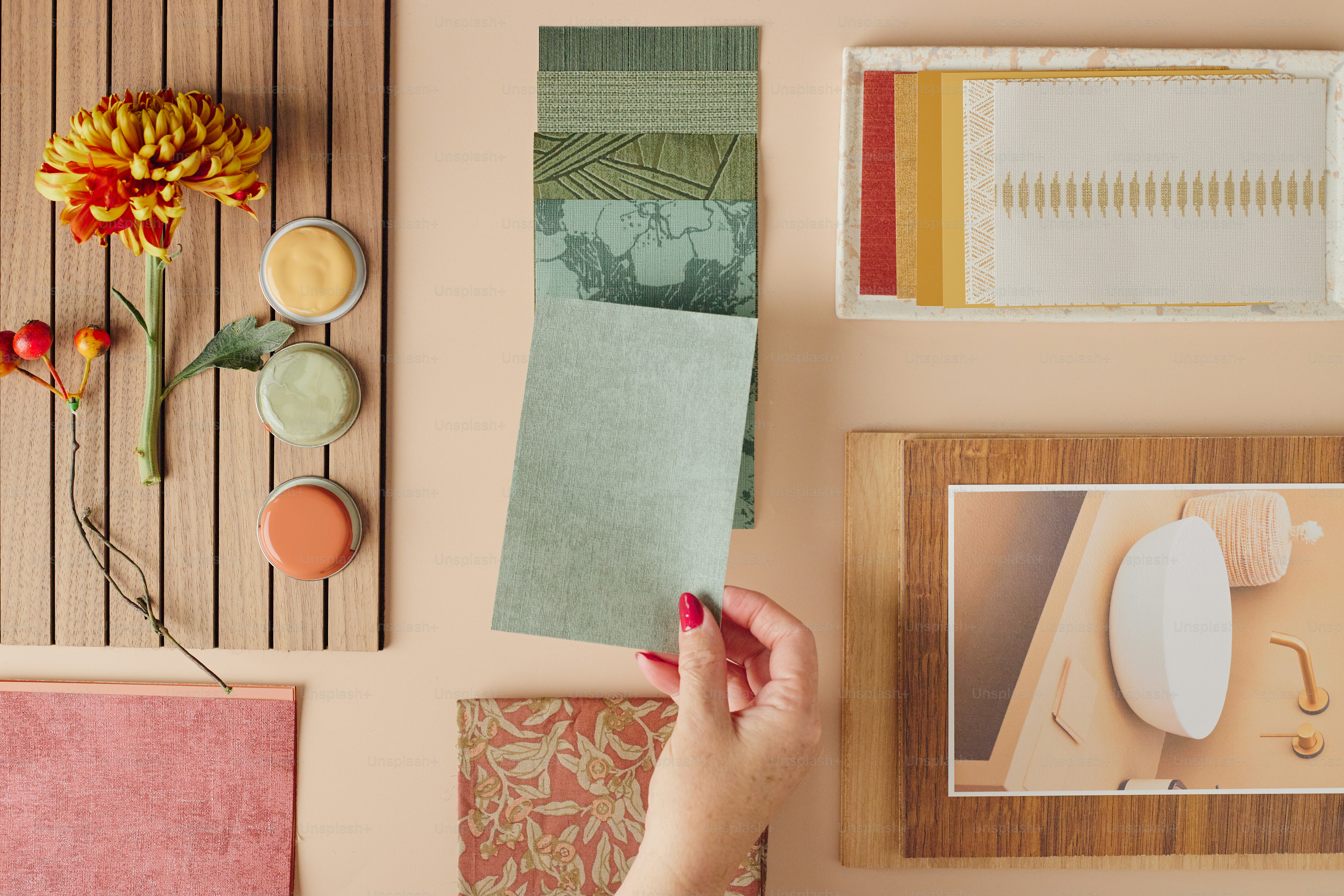 Hand selecting fabric swatches with floral and art elements.