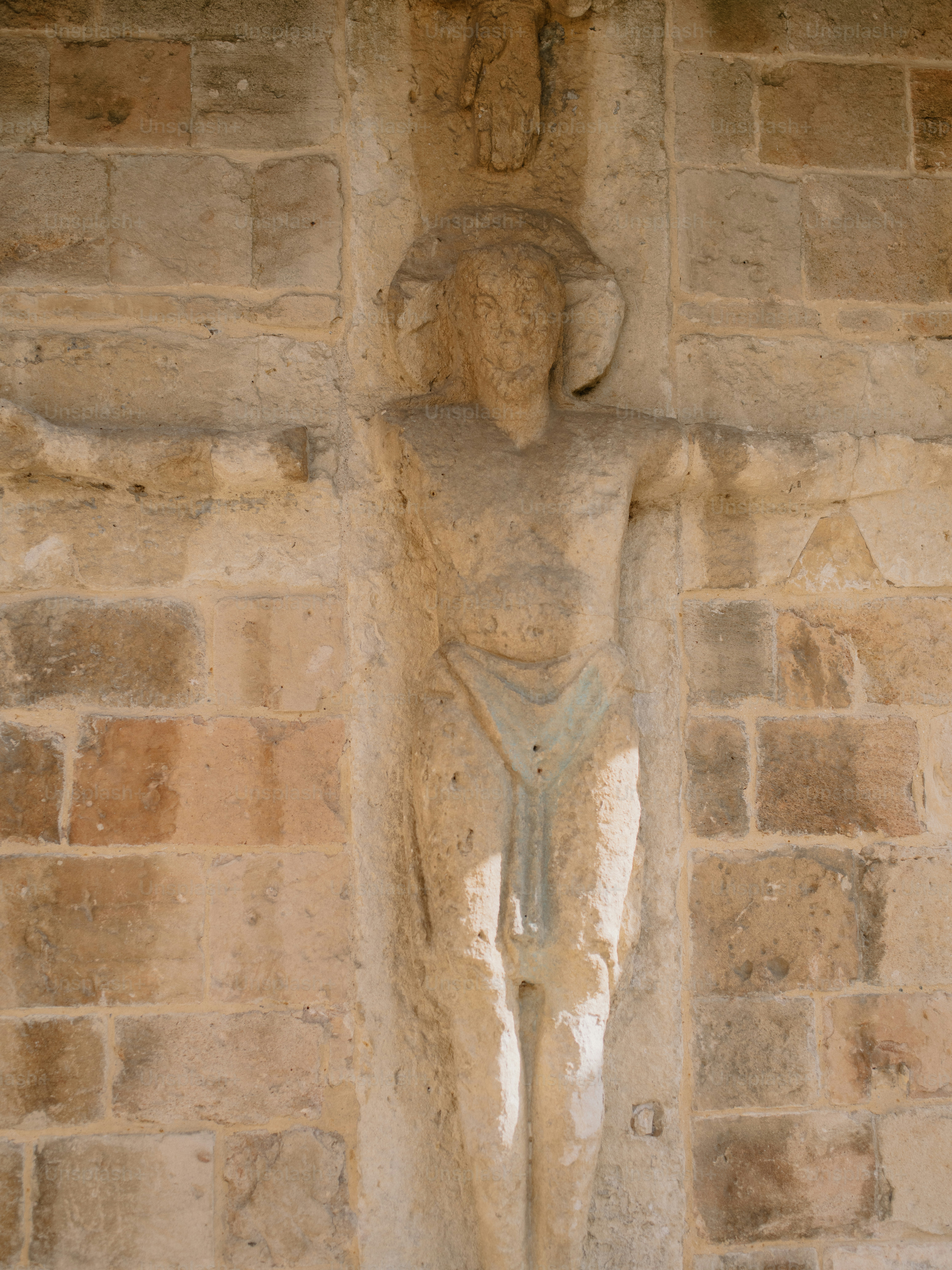 Stone carving of a man on a textured wall