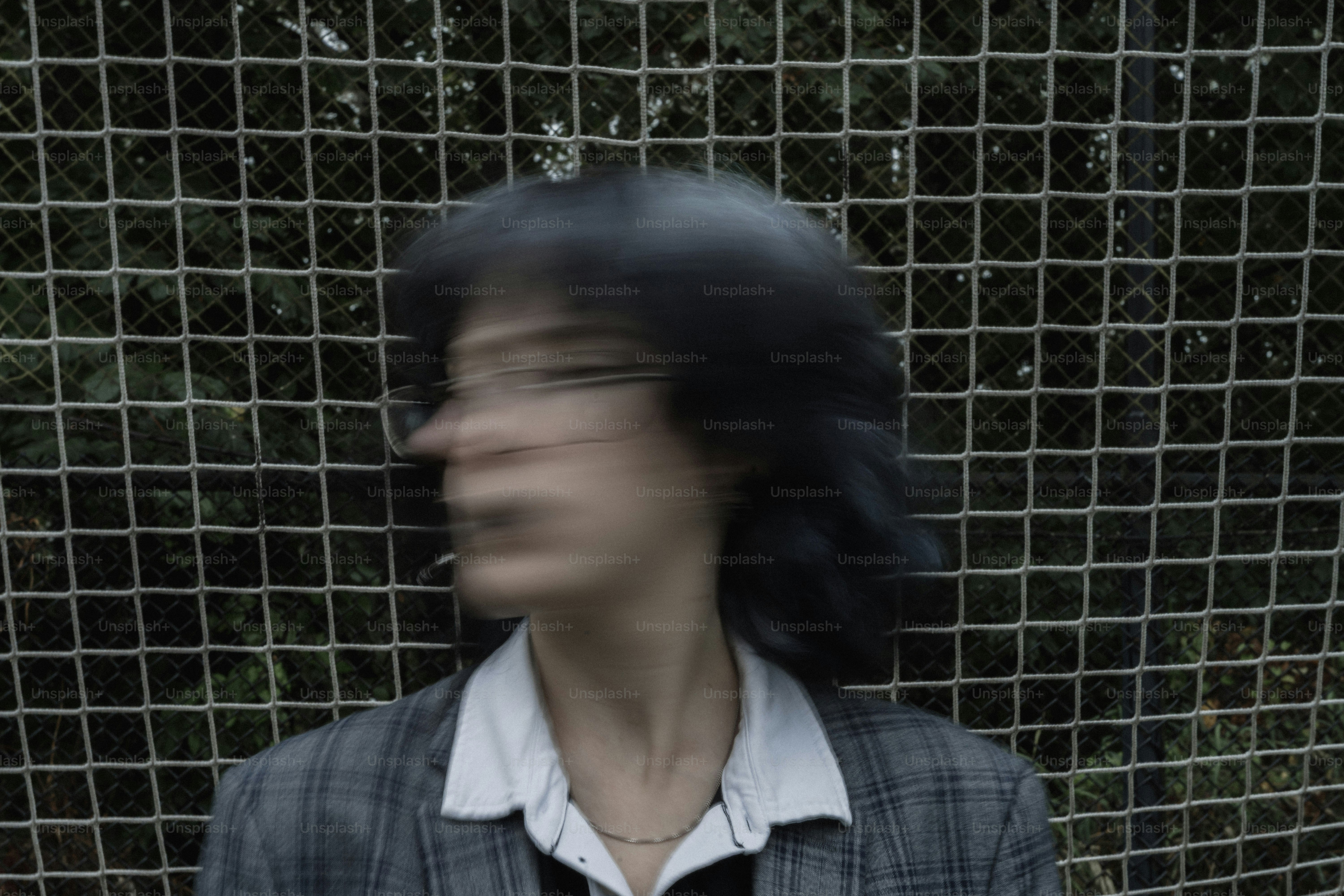 Person with dark hair turns head against net