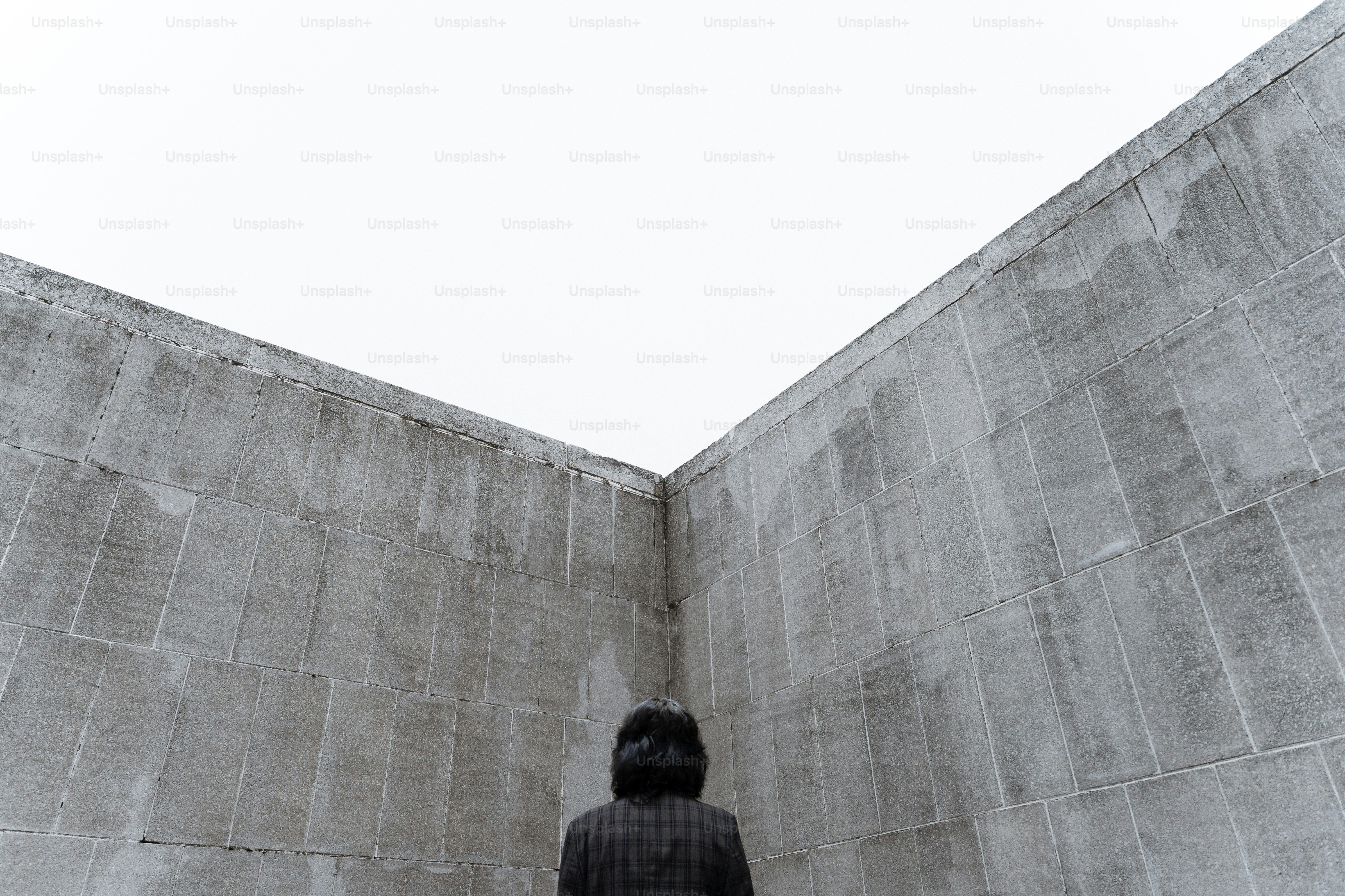 Person stands in a concrete corner looking up