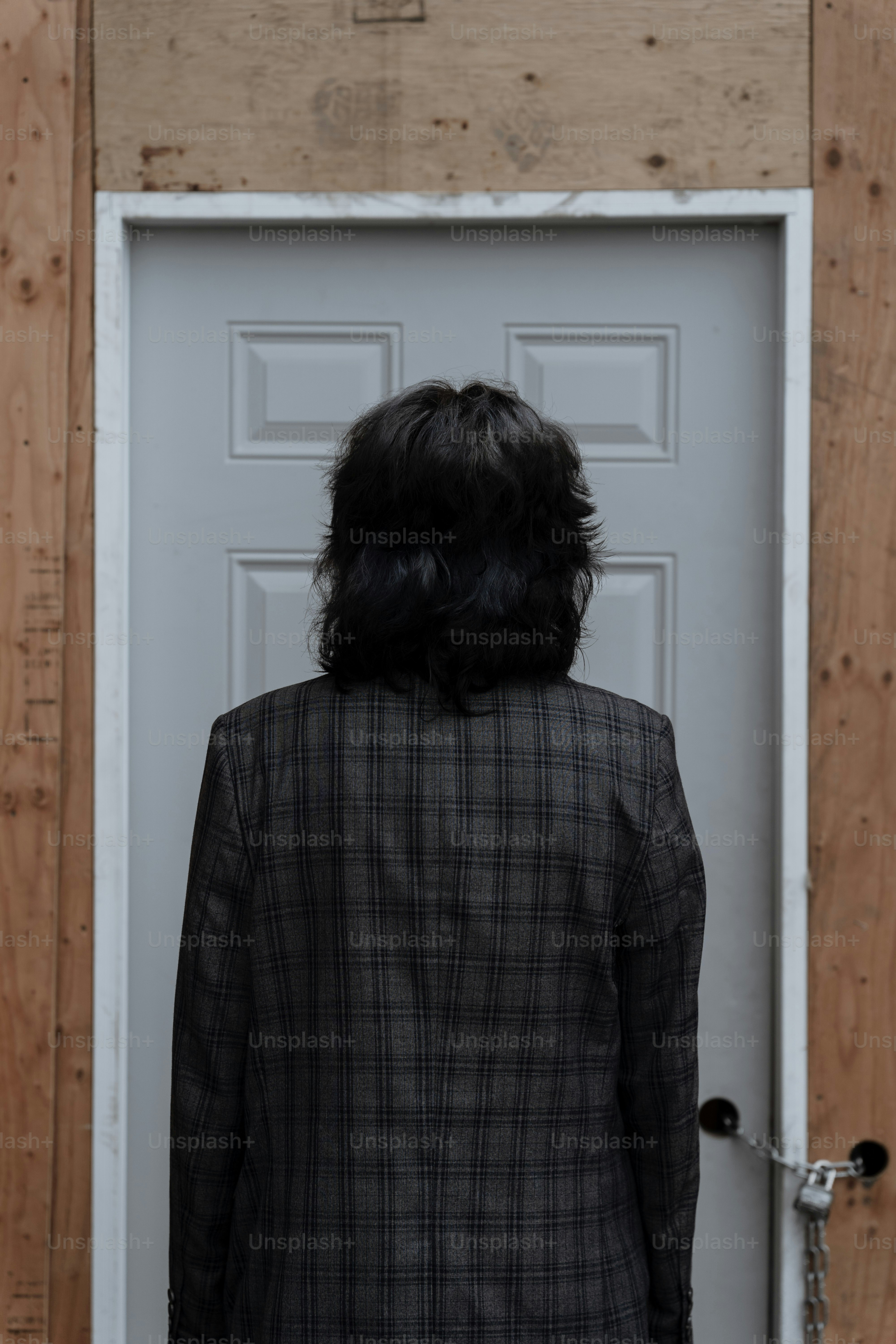 Person in plaid jacket facing locked door