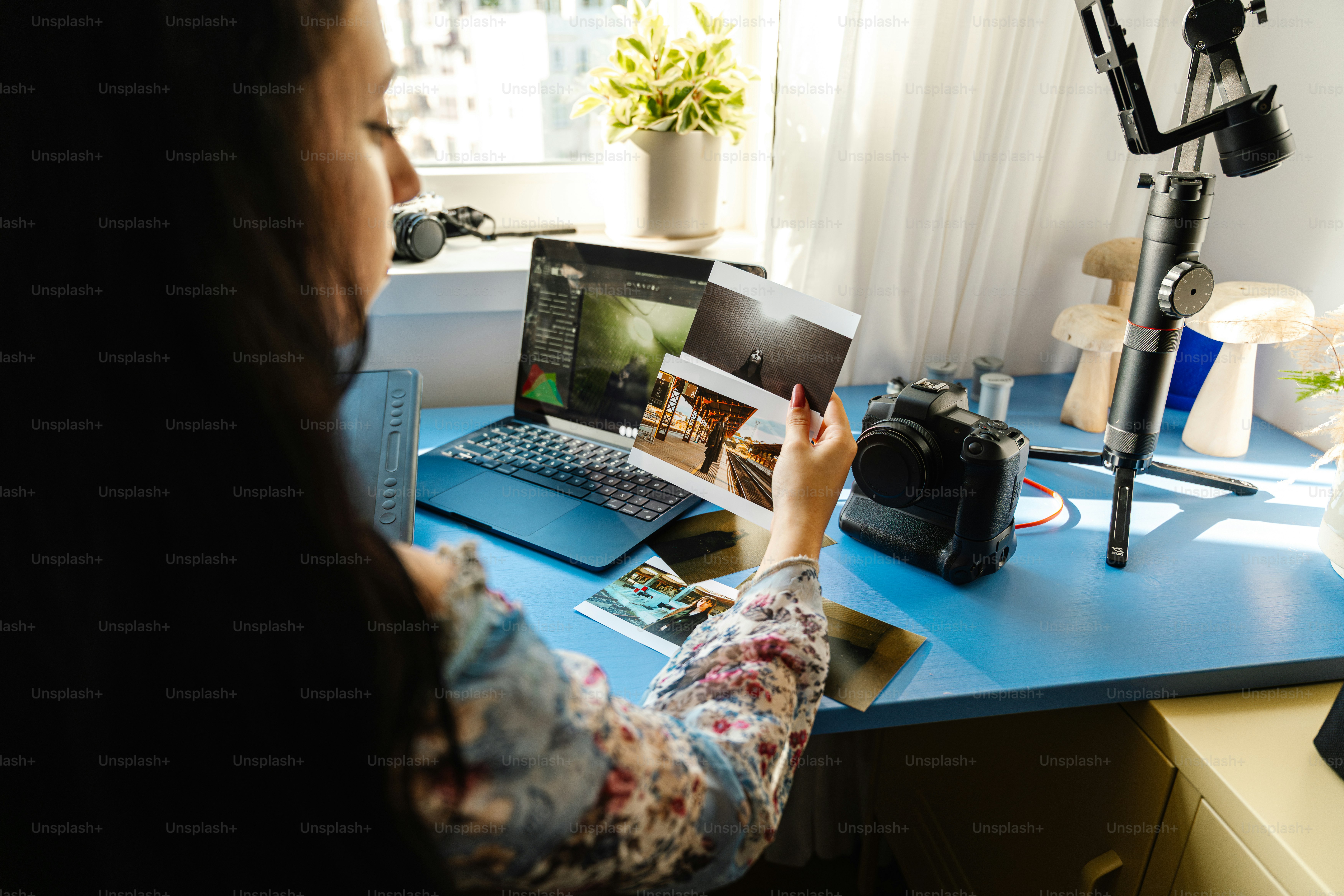 Woman looking at printed photographs at a desk