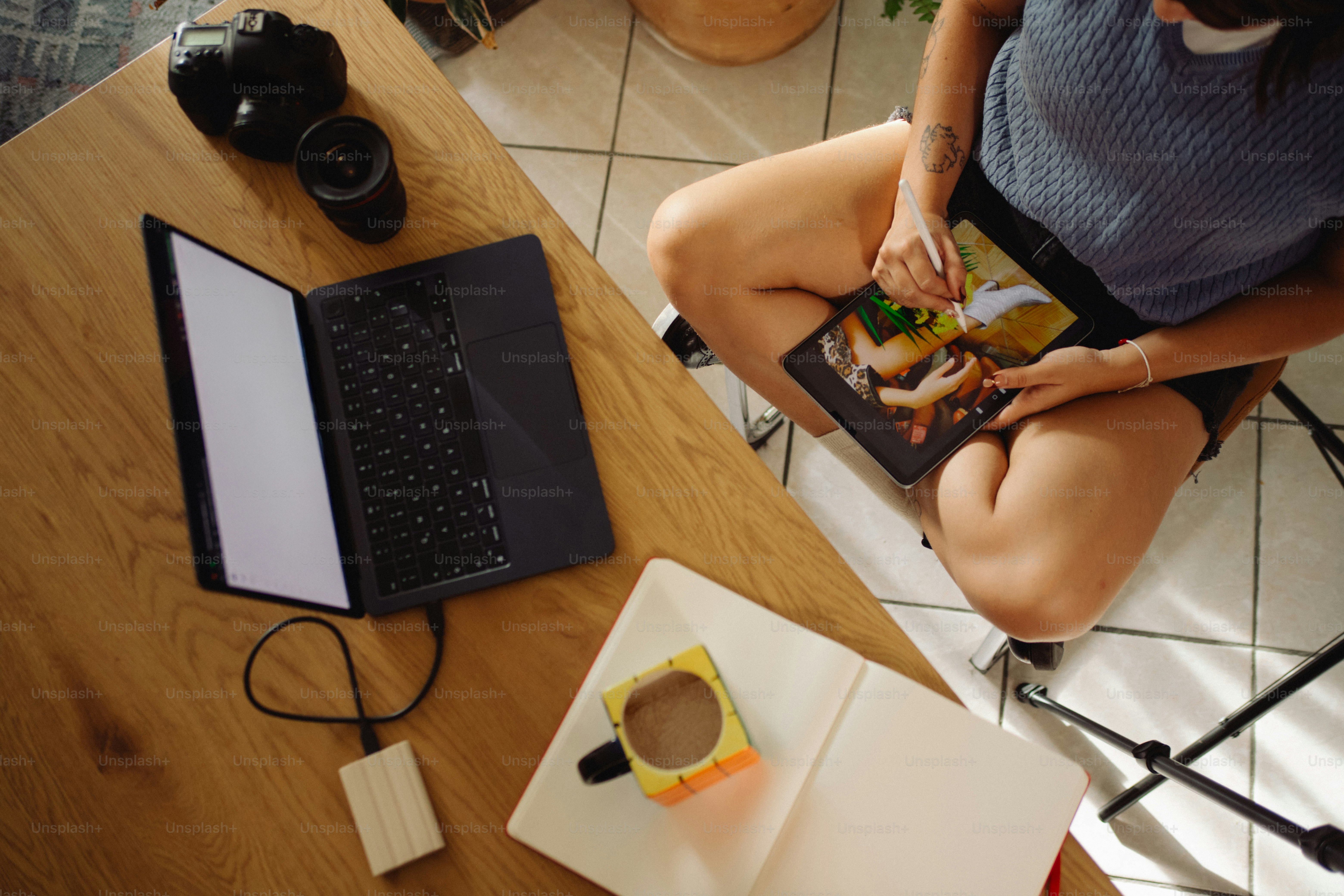 Person editing food photo on tablet next to laptop