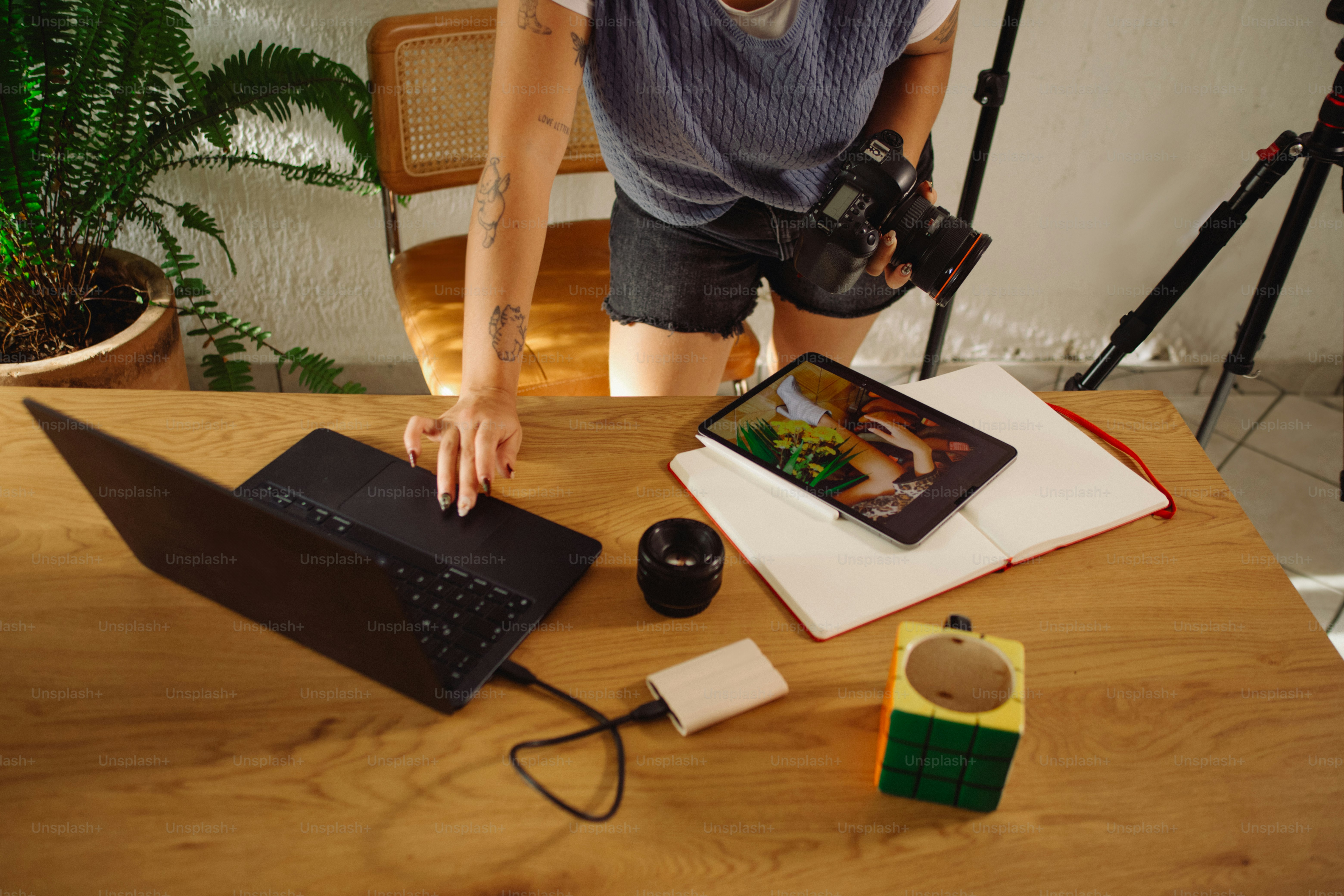 Person working at a desk with laptop and camera.