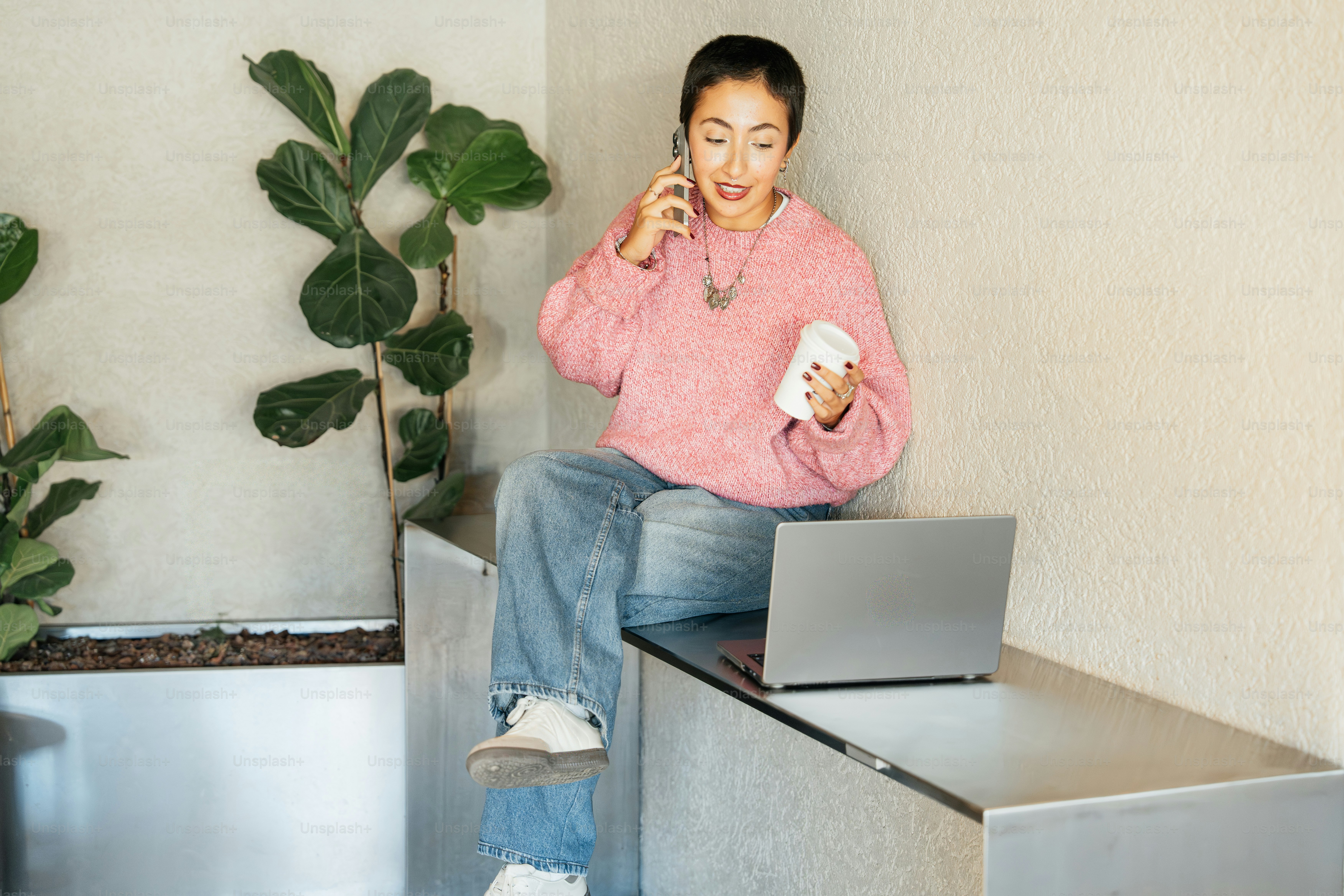 Woman talking on phone with laptop nearby.