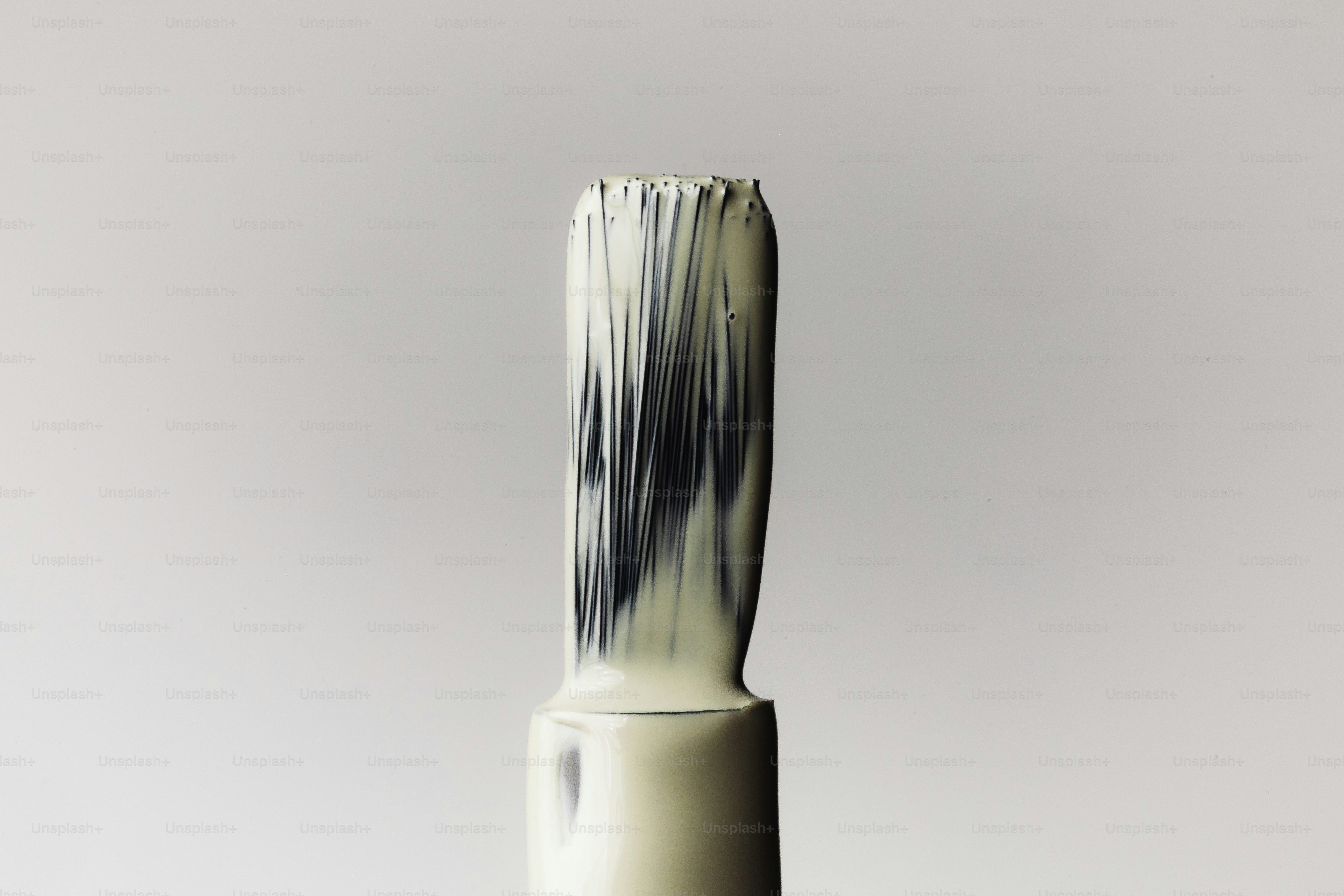 Gros plan d’un pinceau à vernis à ongles avec du vernis blanc