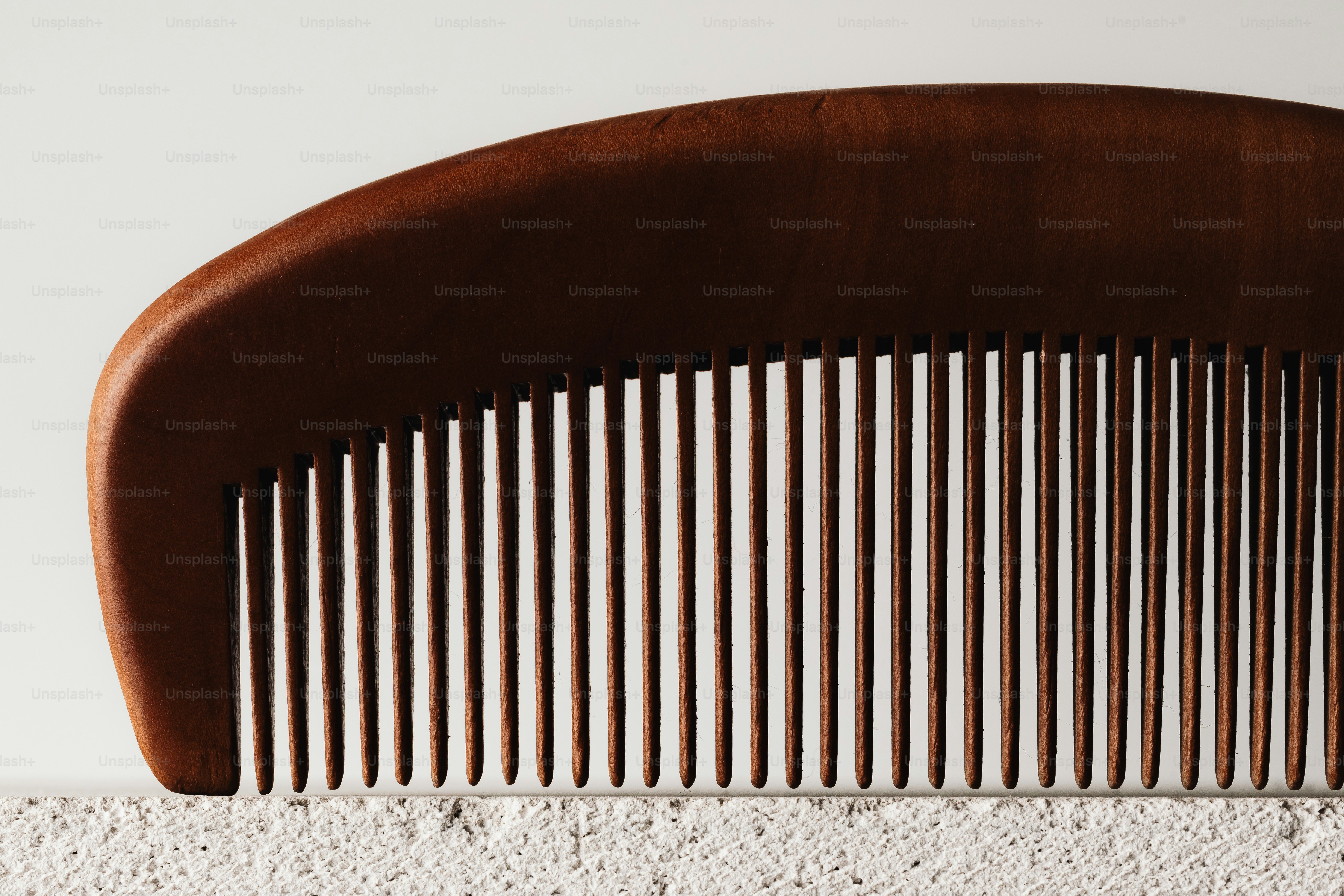 A dark wooden comb with fine teeth