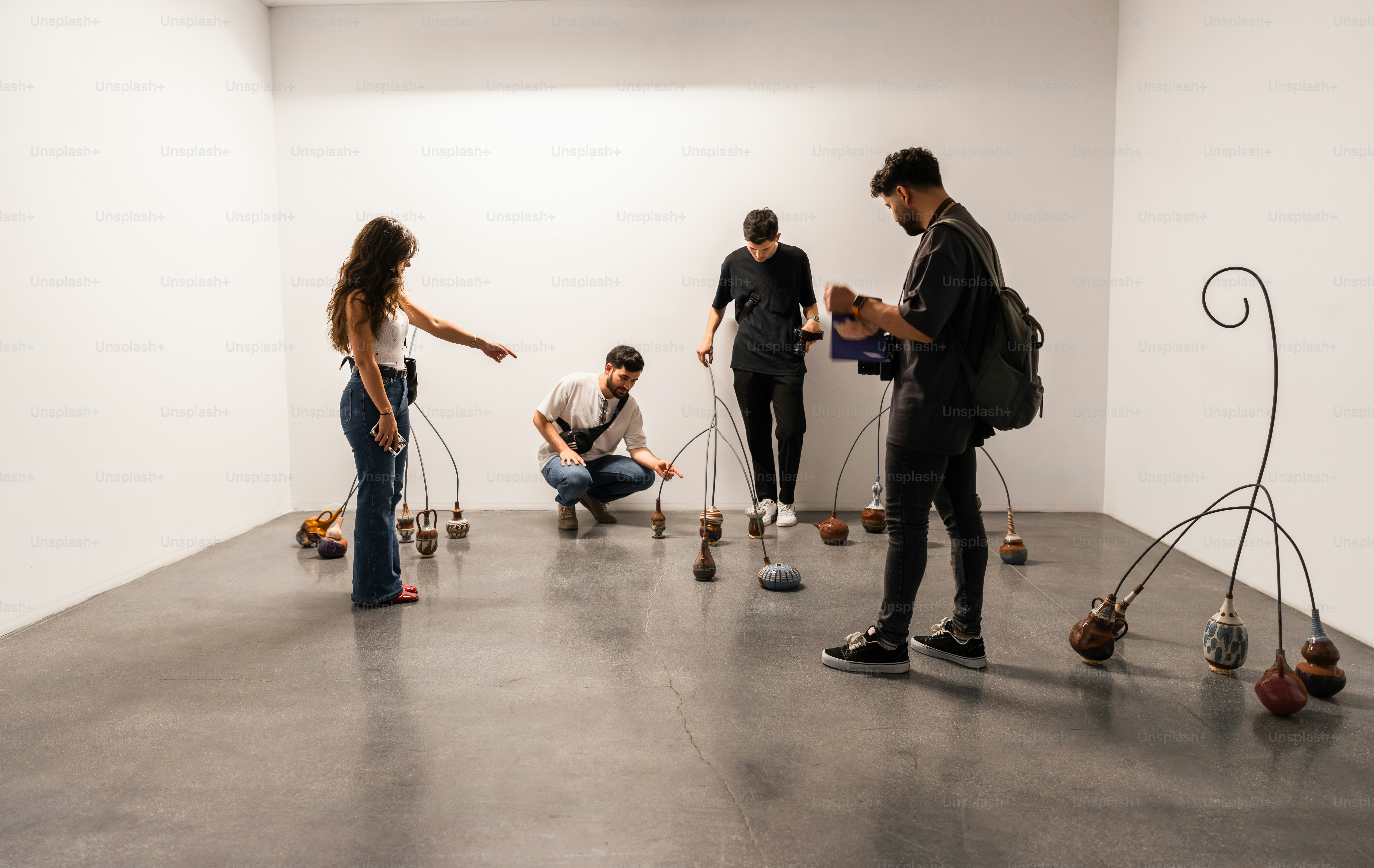People observe modern art installation in a white gallery.