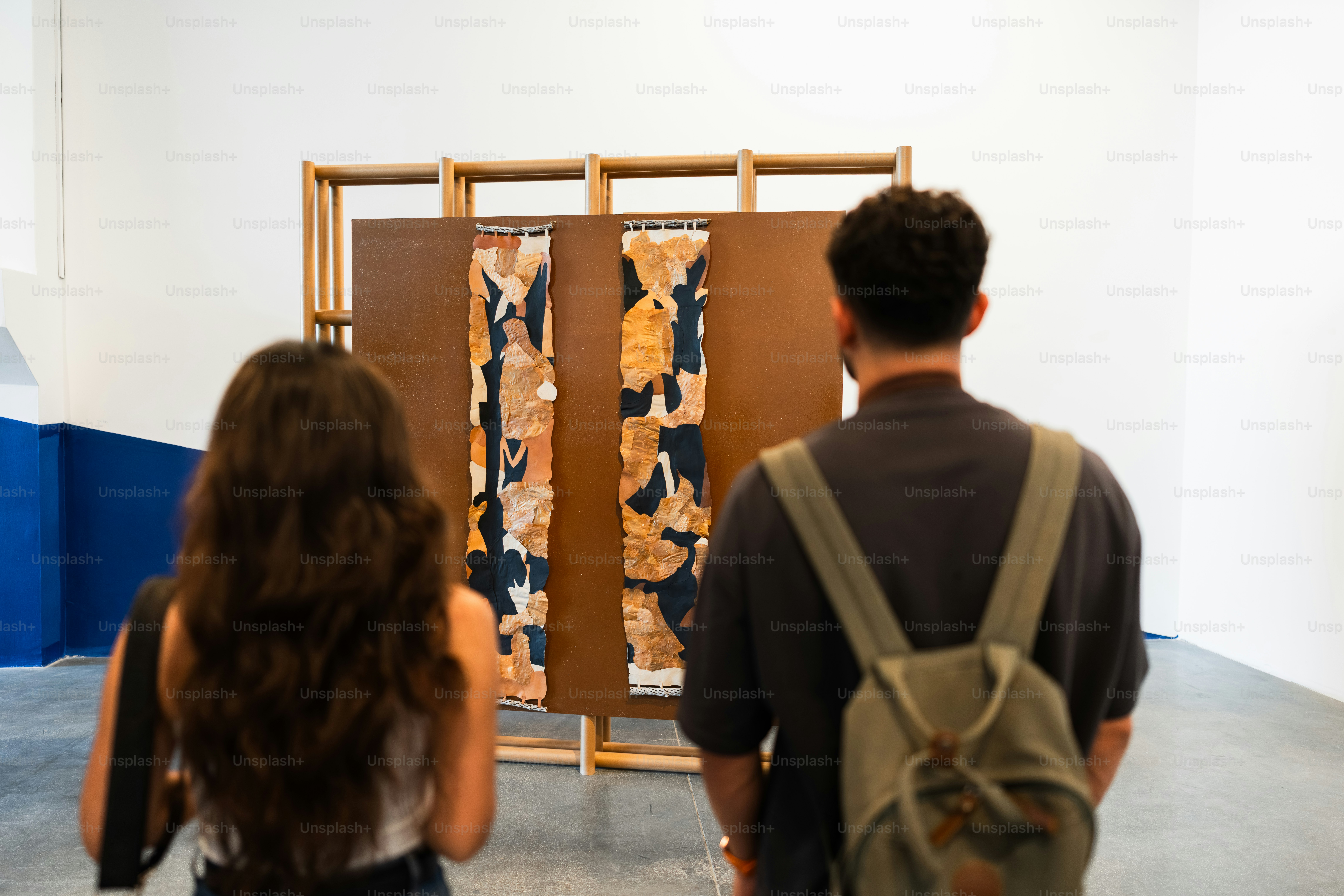 Two people observe art in a gallery setting. photo – Art Image on Unsplash