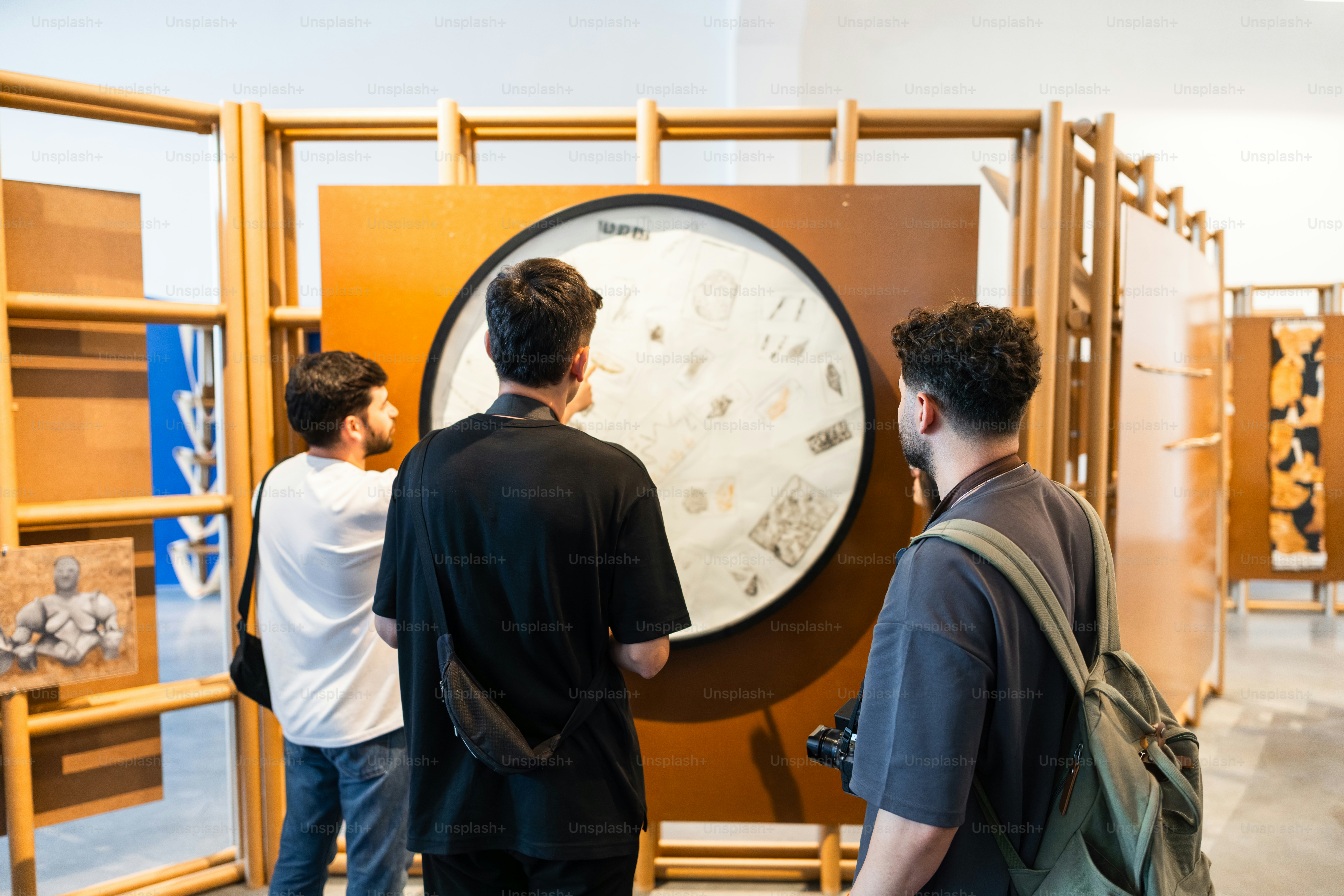 Orang-orang mengamati tampilan melingkar dalam pameran modern.