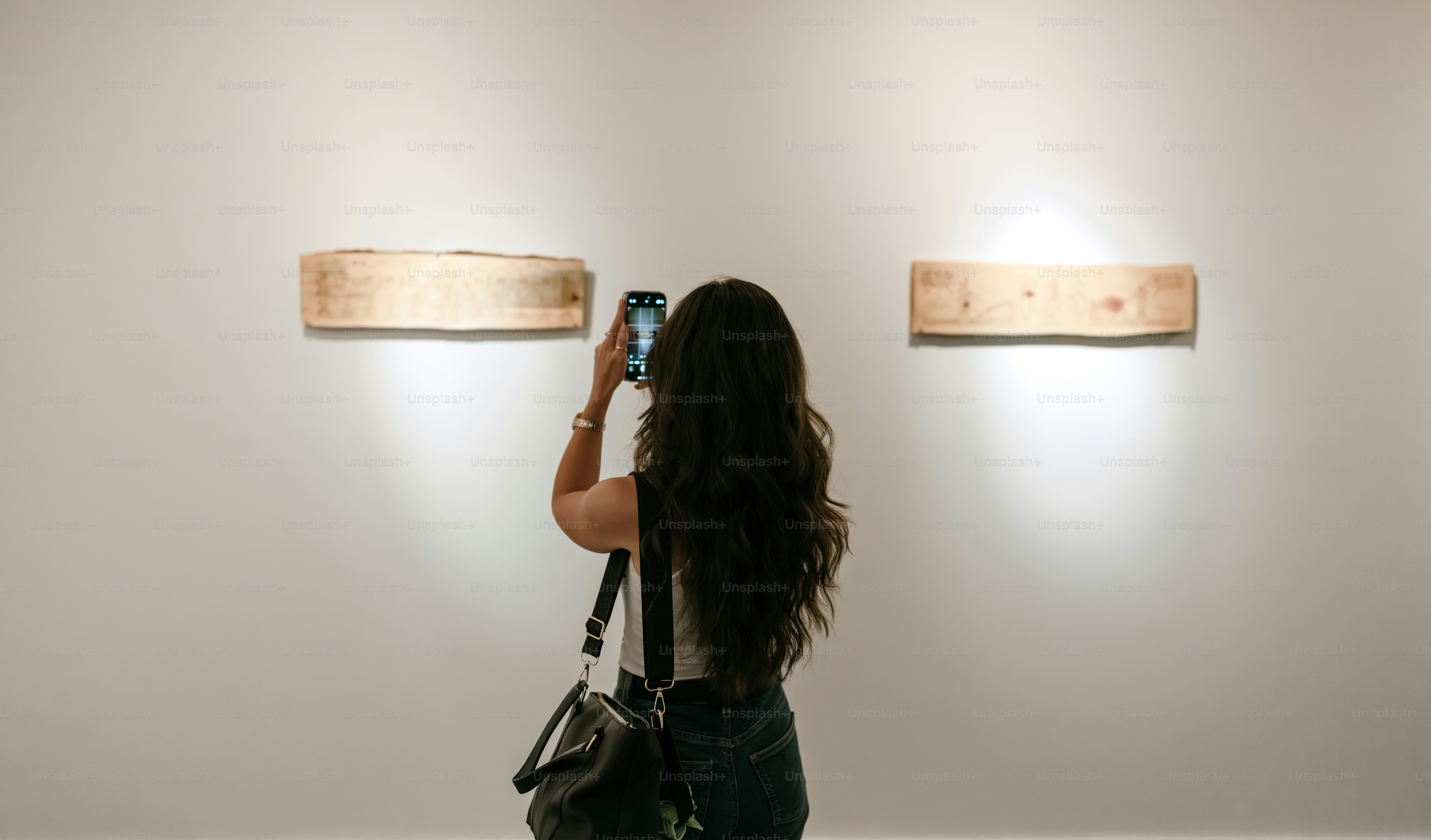 Woman taking a picture of art in a gallery.