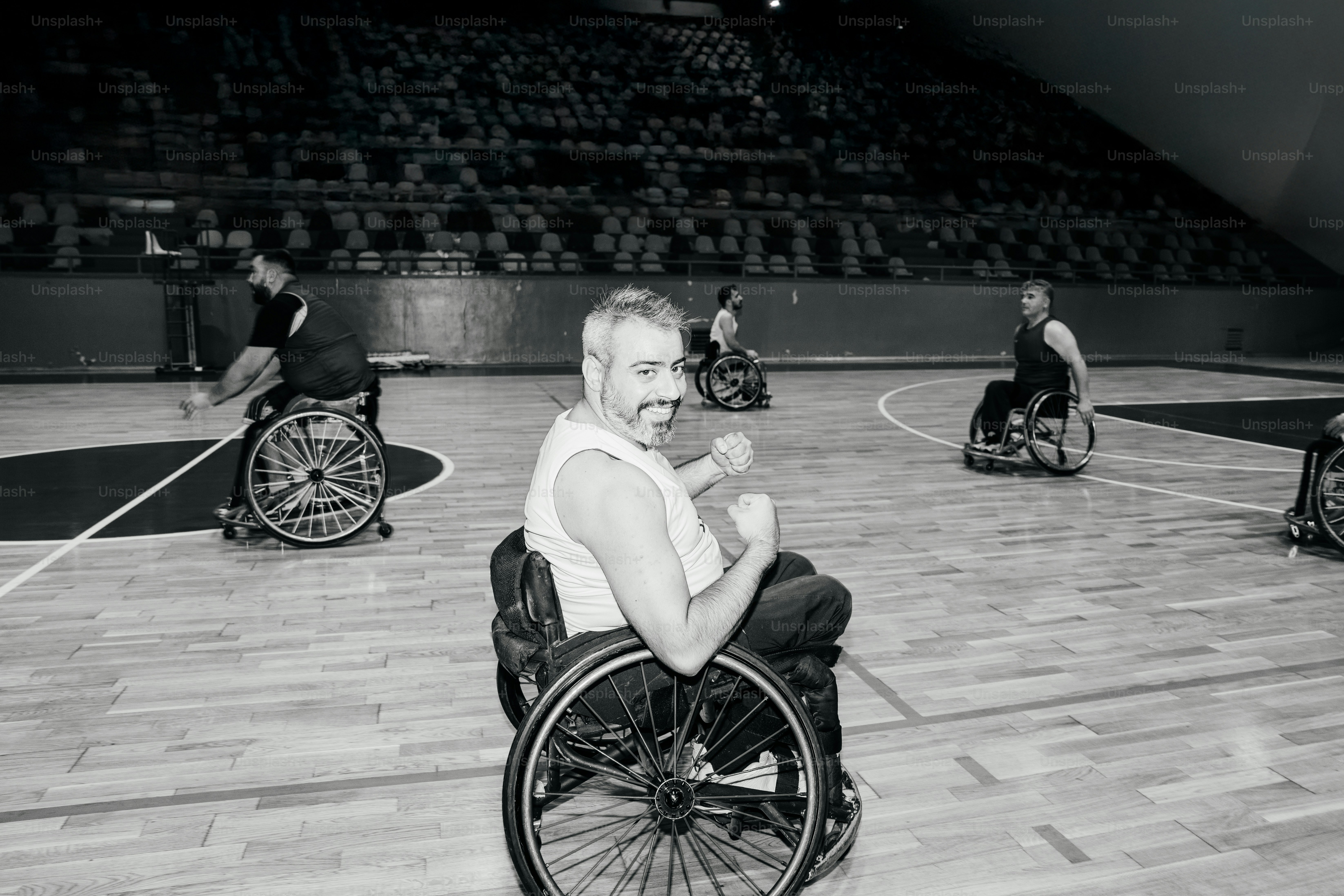 Männer, die in einer Arena Rollstuhlbasketball spielen.