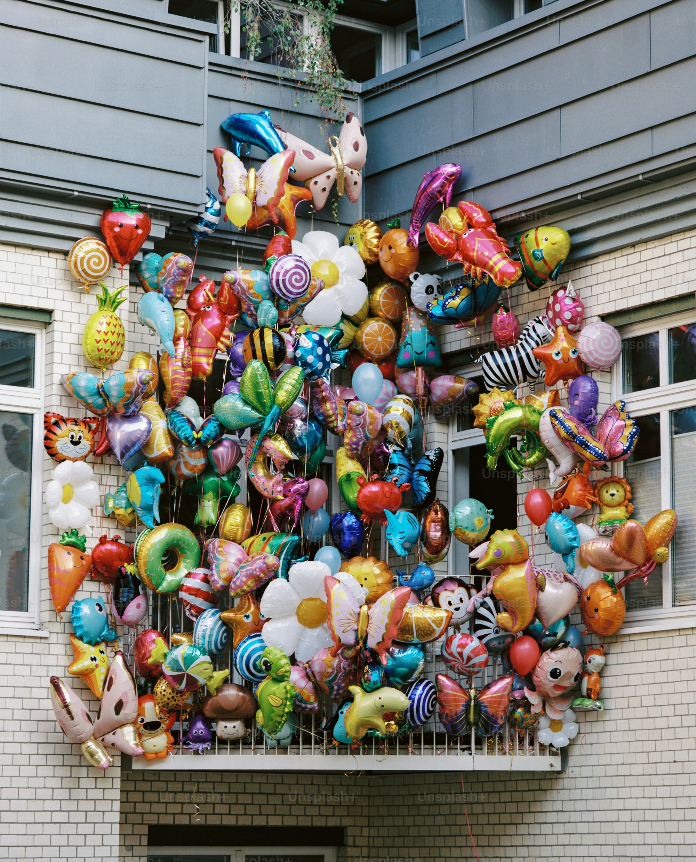 Ein Balkon gefüllt mit bunten Tier- und Blumenballons.