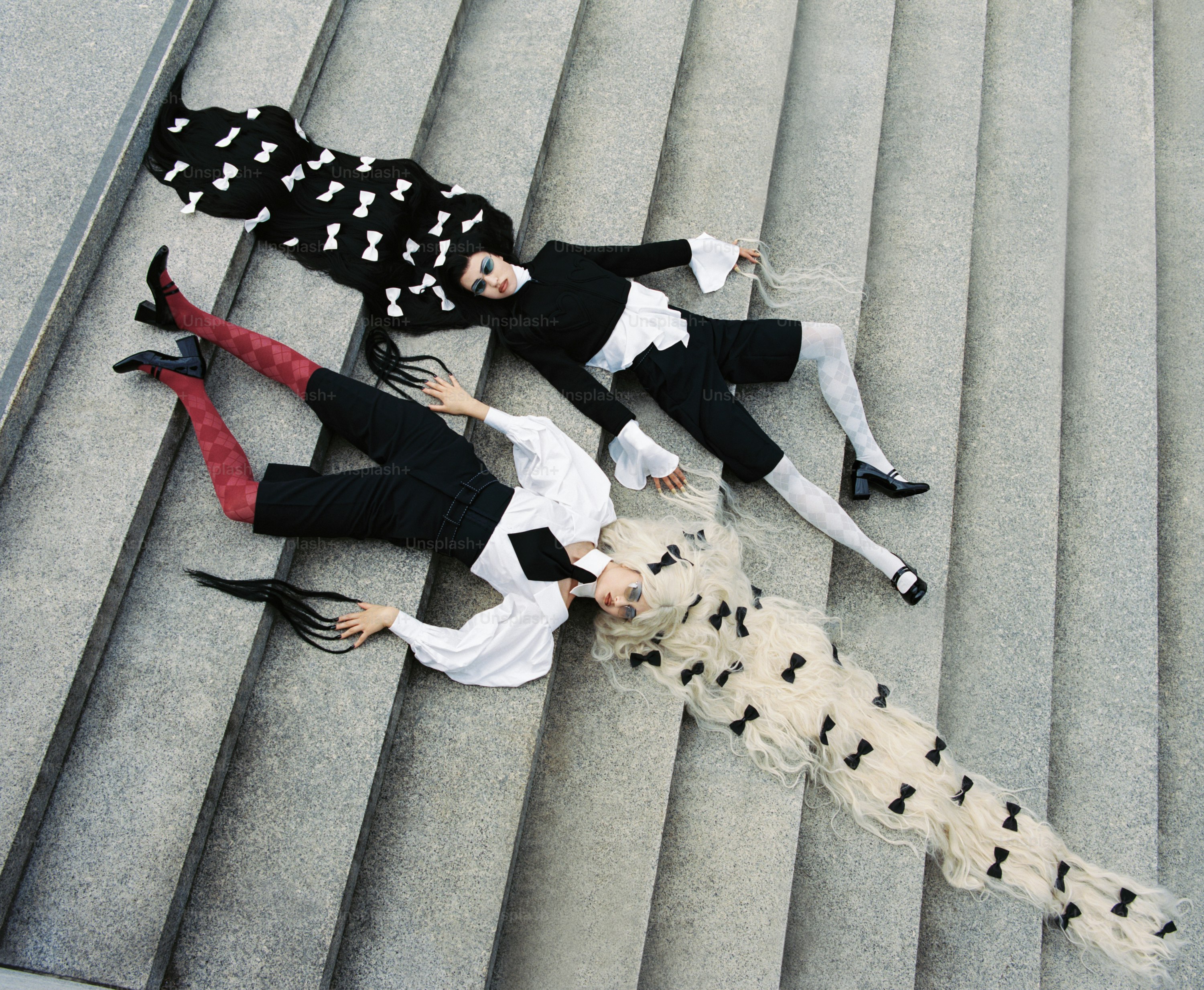 Zwei Modelle mit langen Schleifen im Haar auf Treppen