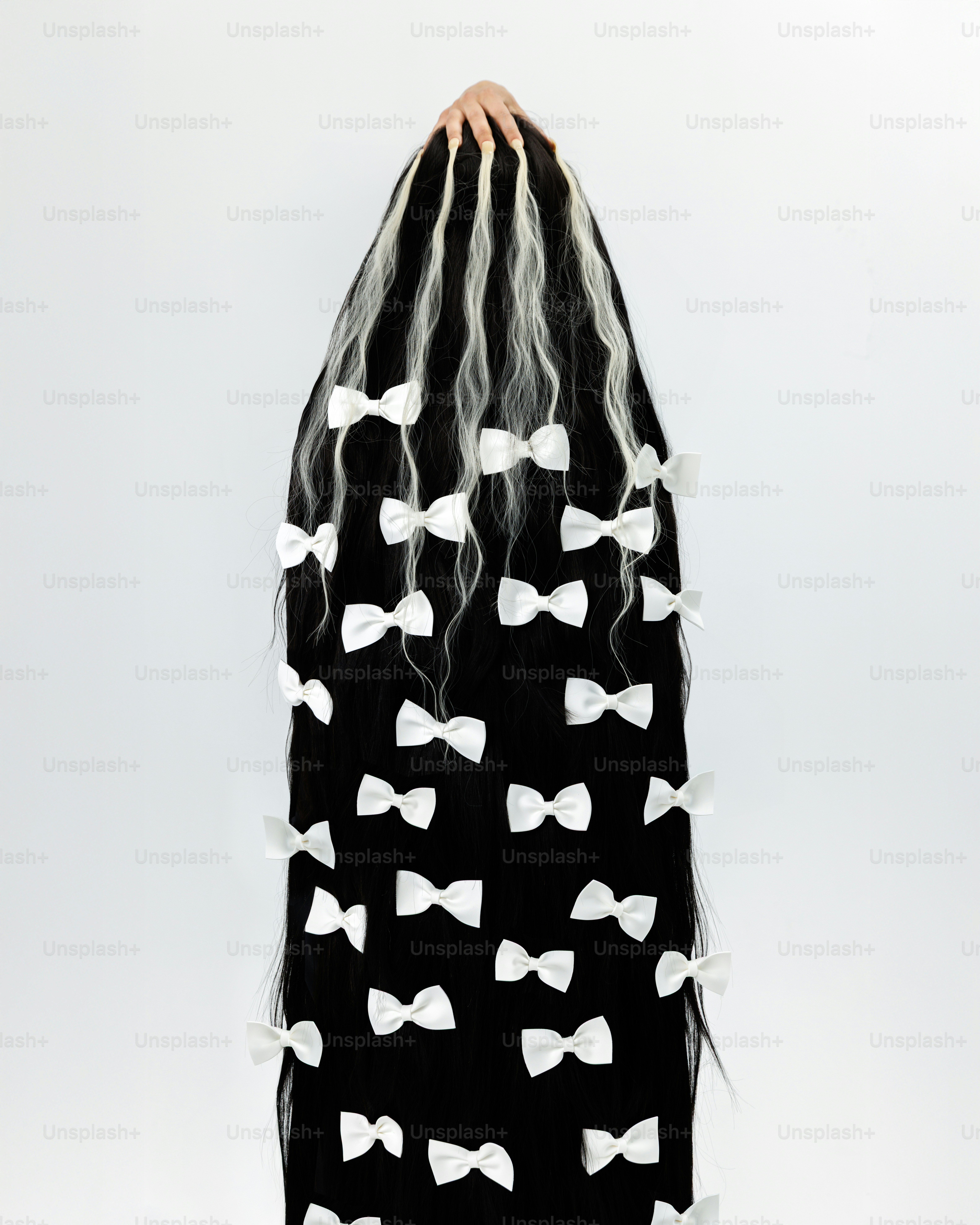 Longs cheveux noirs à mèches blanches ornés de nœuds