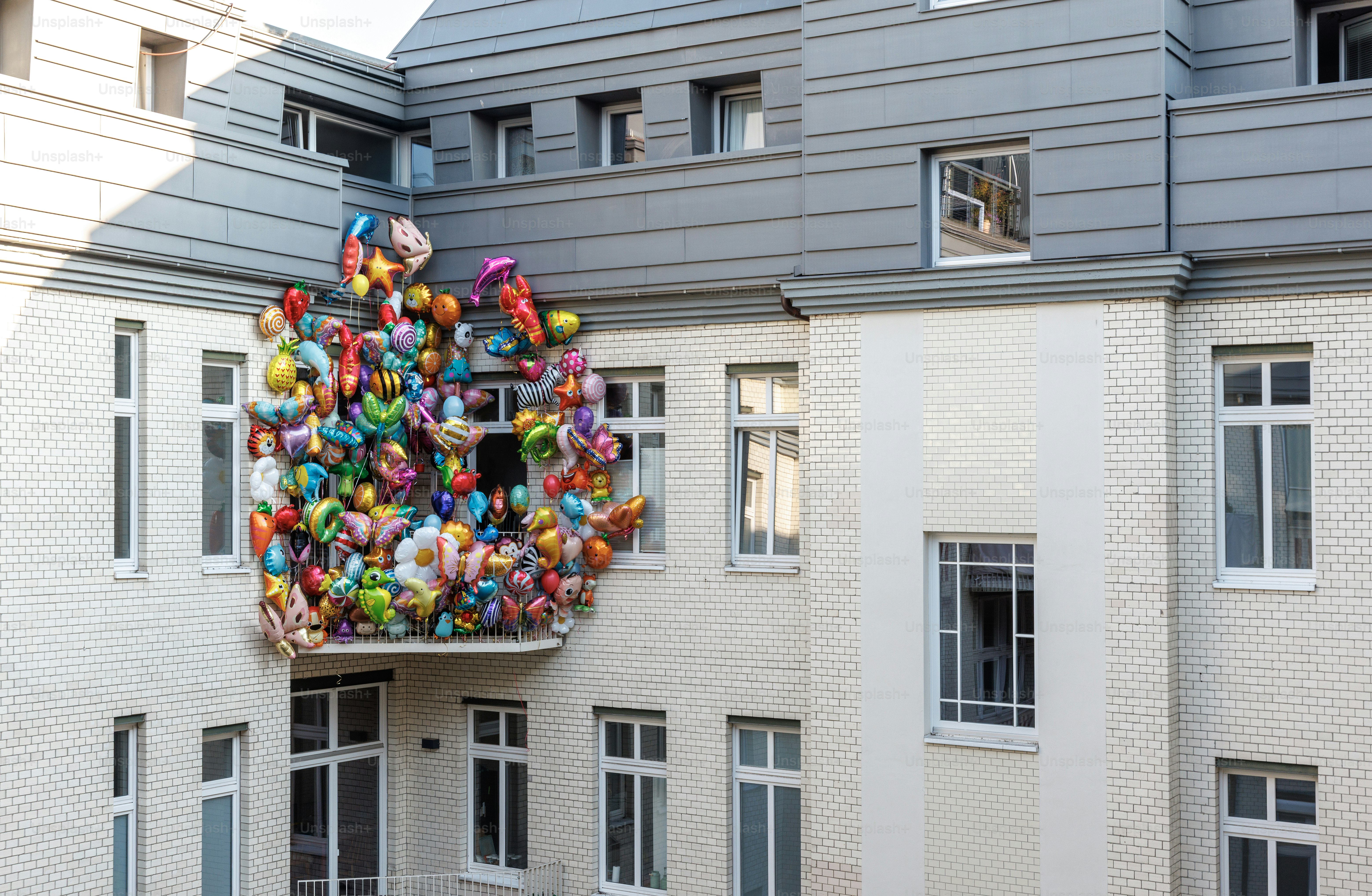 Balkon dipenuhi dengan balon warna-warni di gedung.
