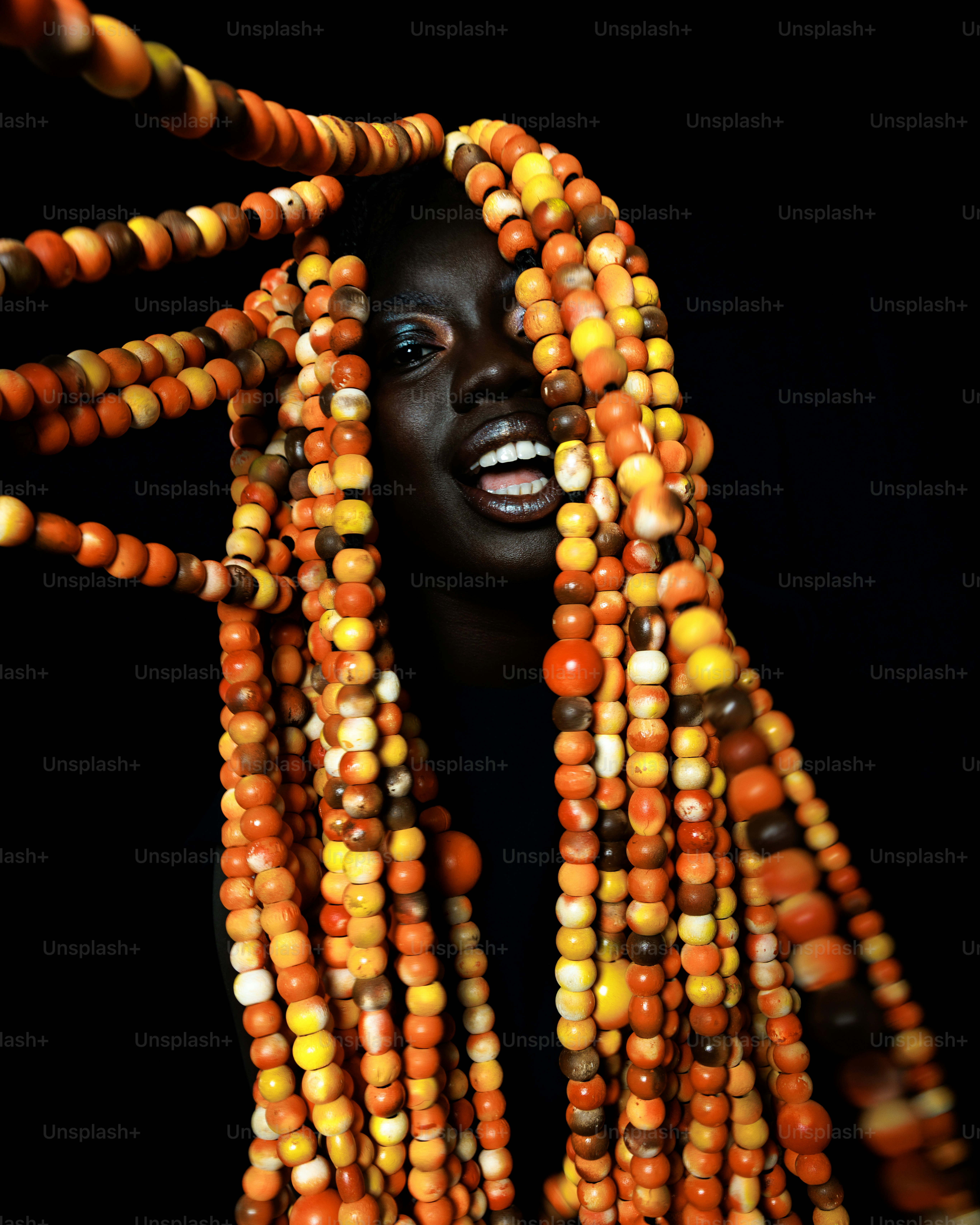 Femme avec des dreadlocks perlées colorées souriant