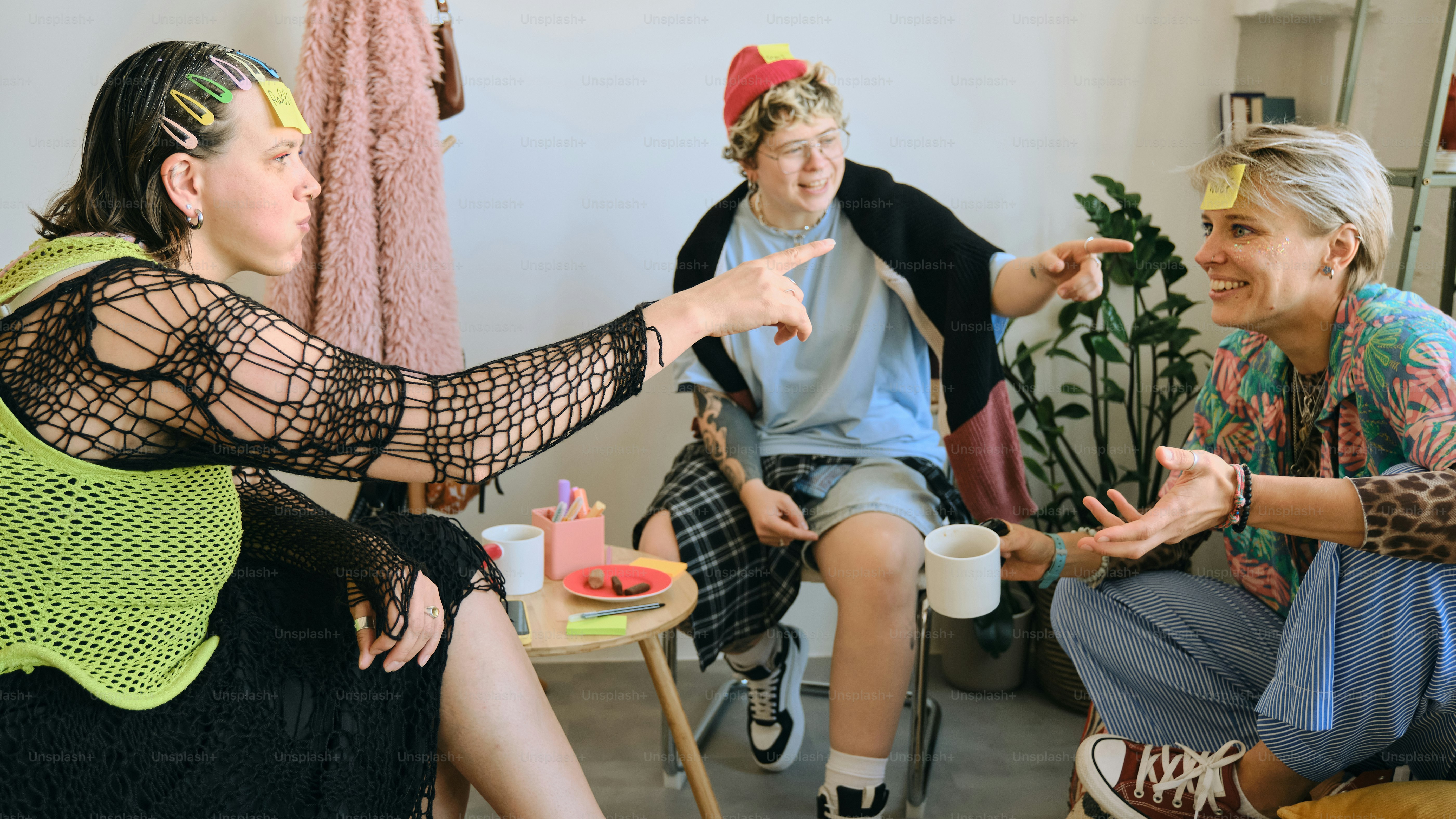 Three friends playing a game with sticky notes on foreheads.
