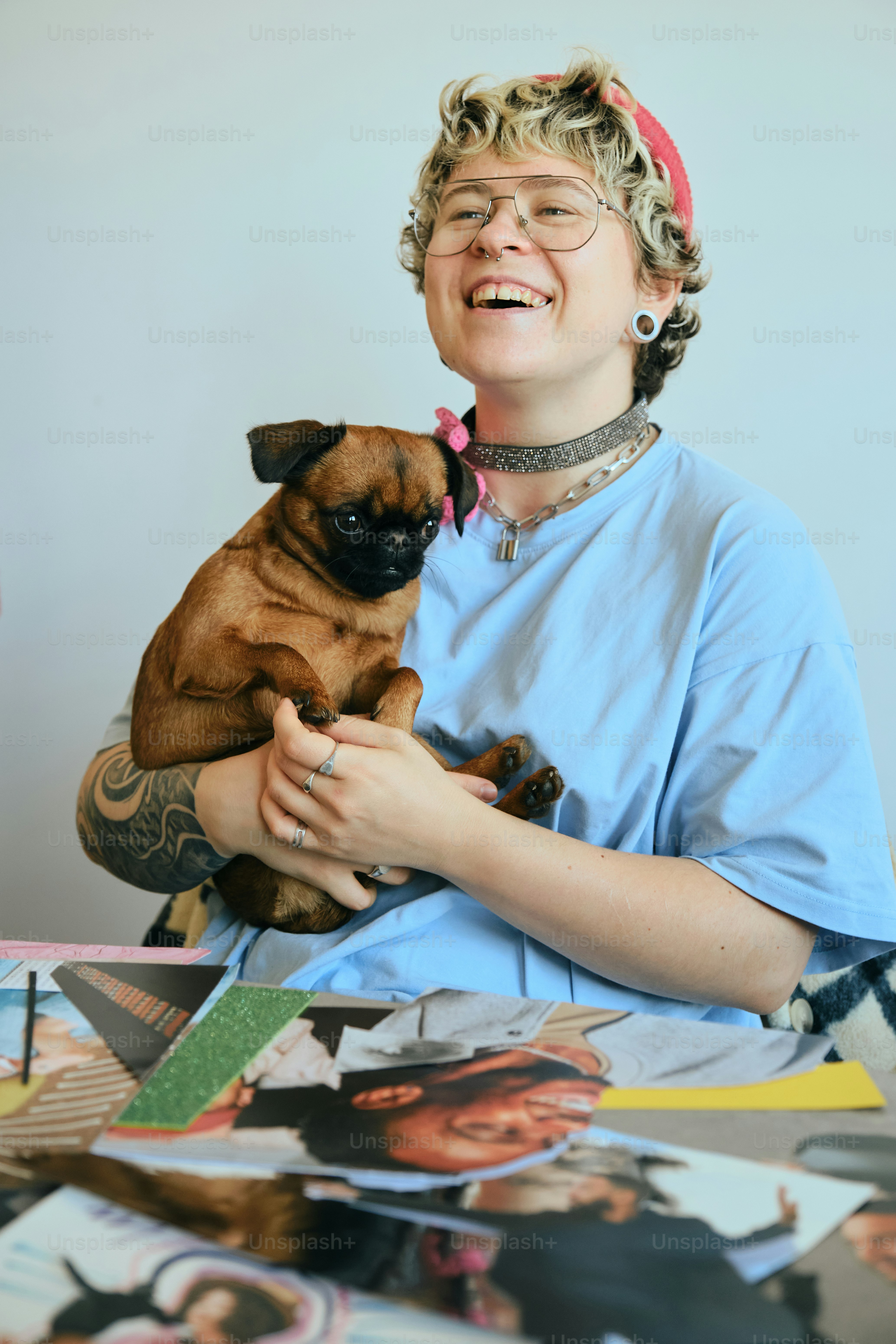 A smiling person holds a small brown dog.