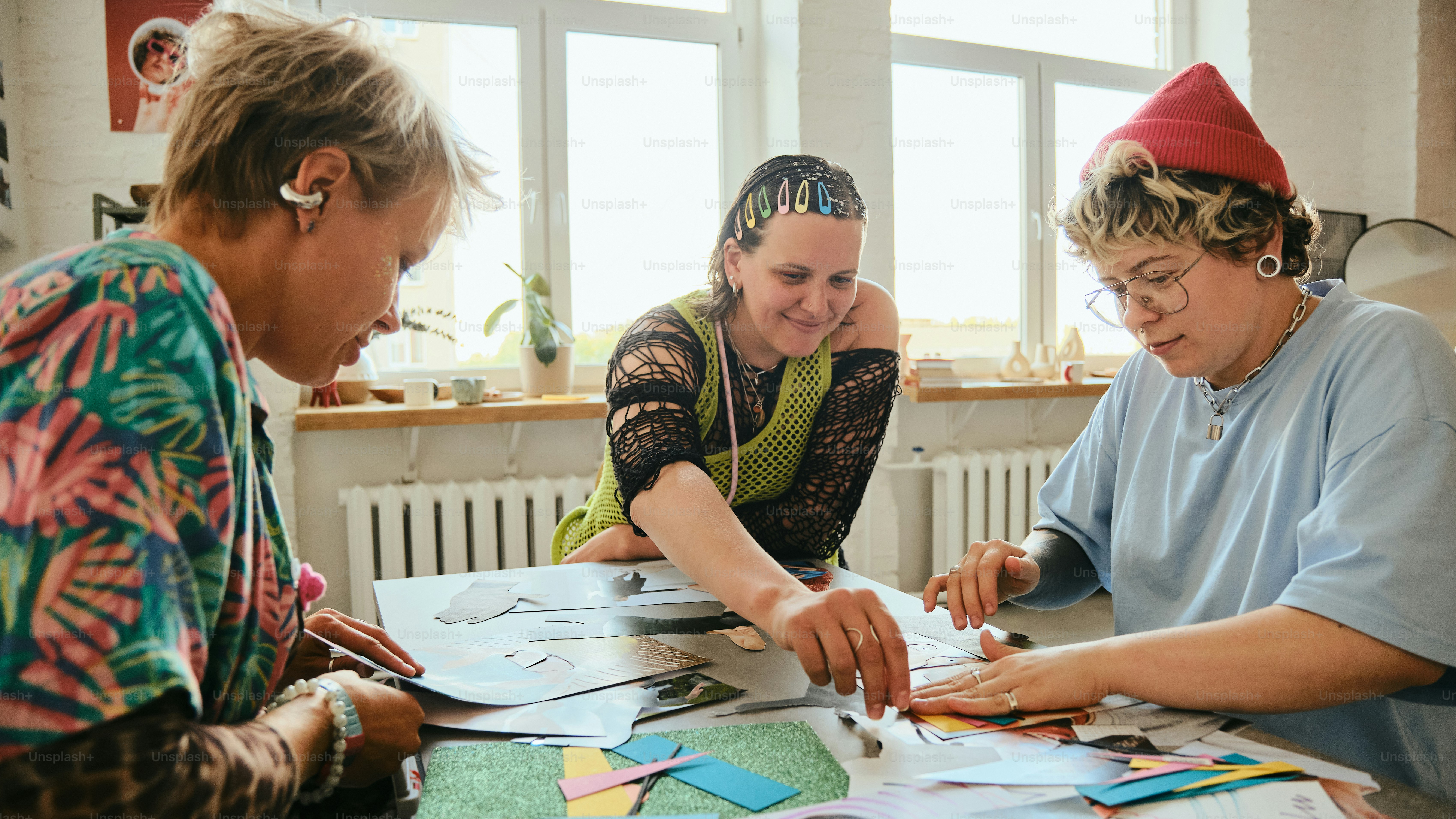 Three women gathered around a table with papers.