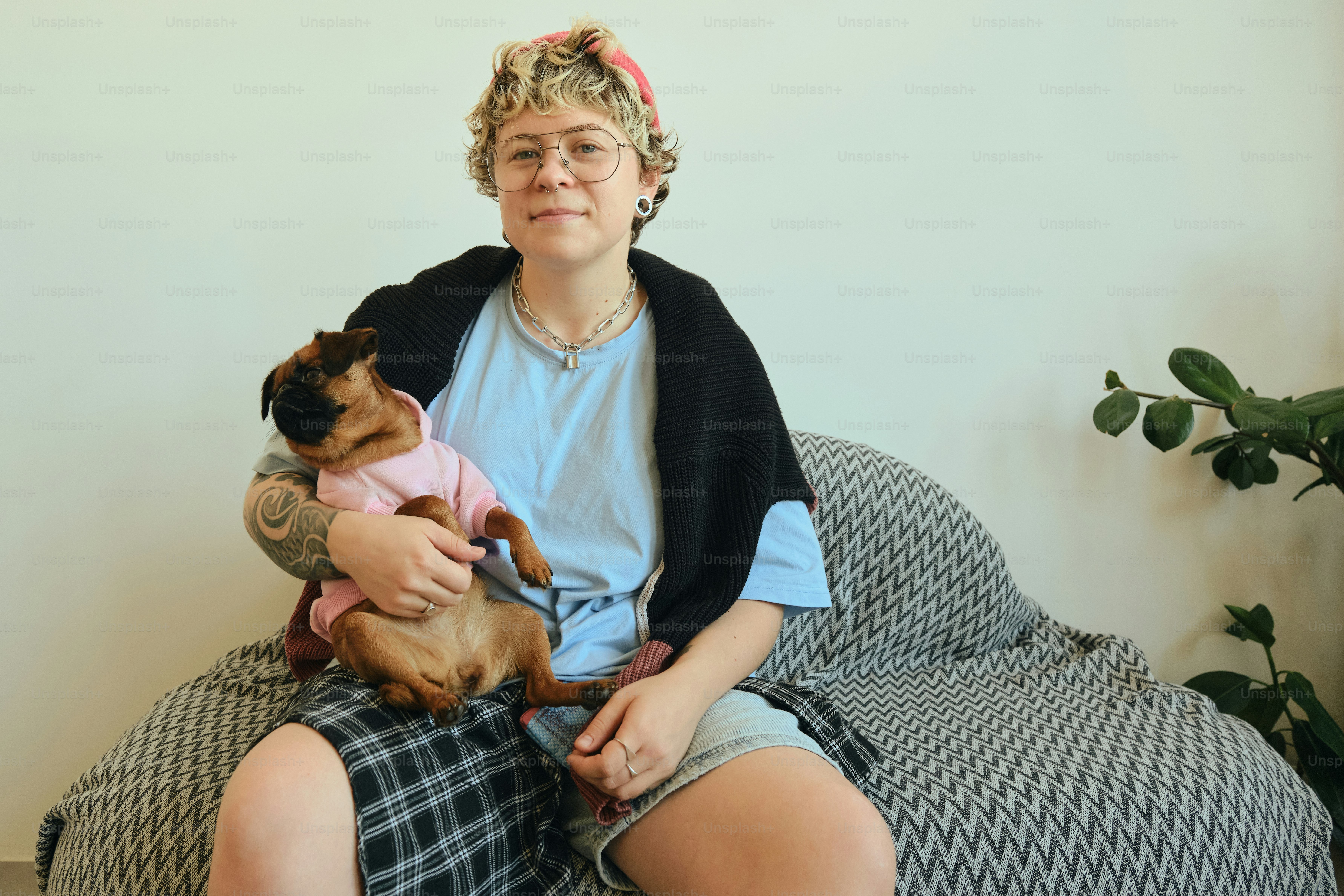 Woman holding a small dog wearing a pink shirt