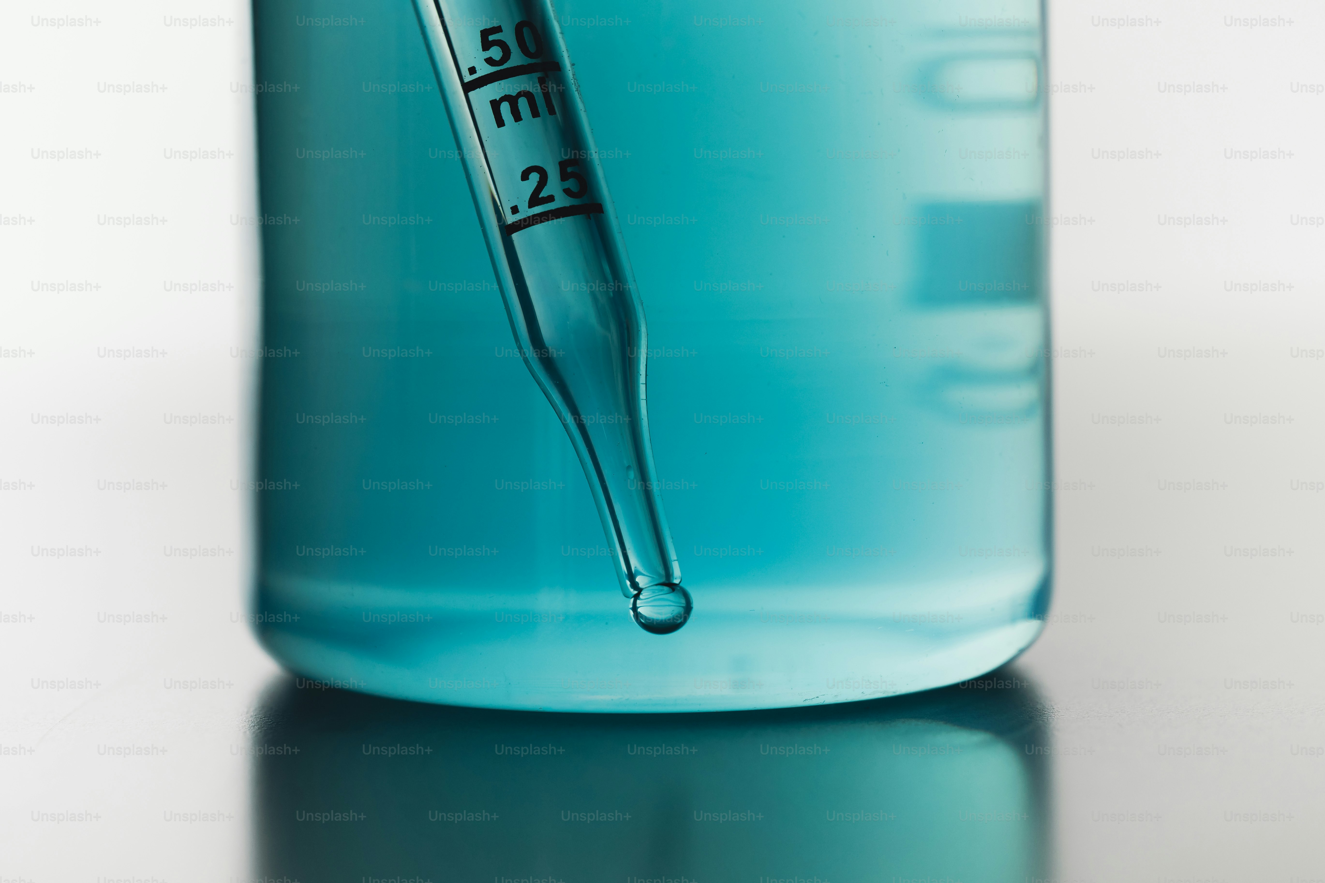 Dropper adding liquid to blue solution in beaker photo – Science Image ...