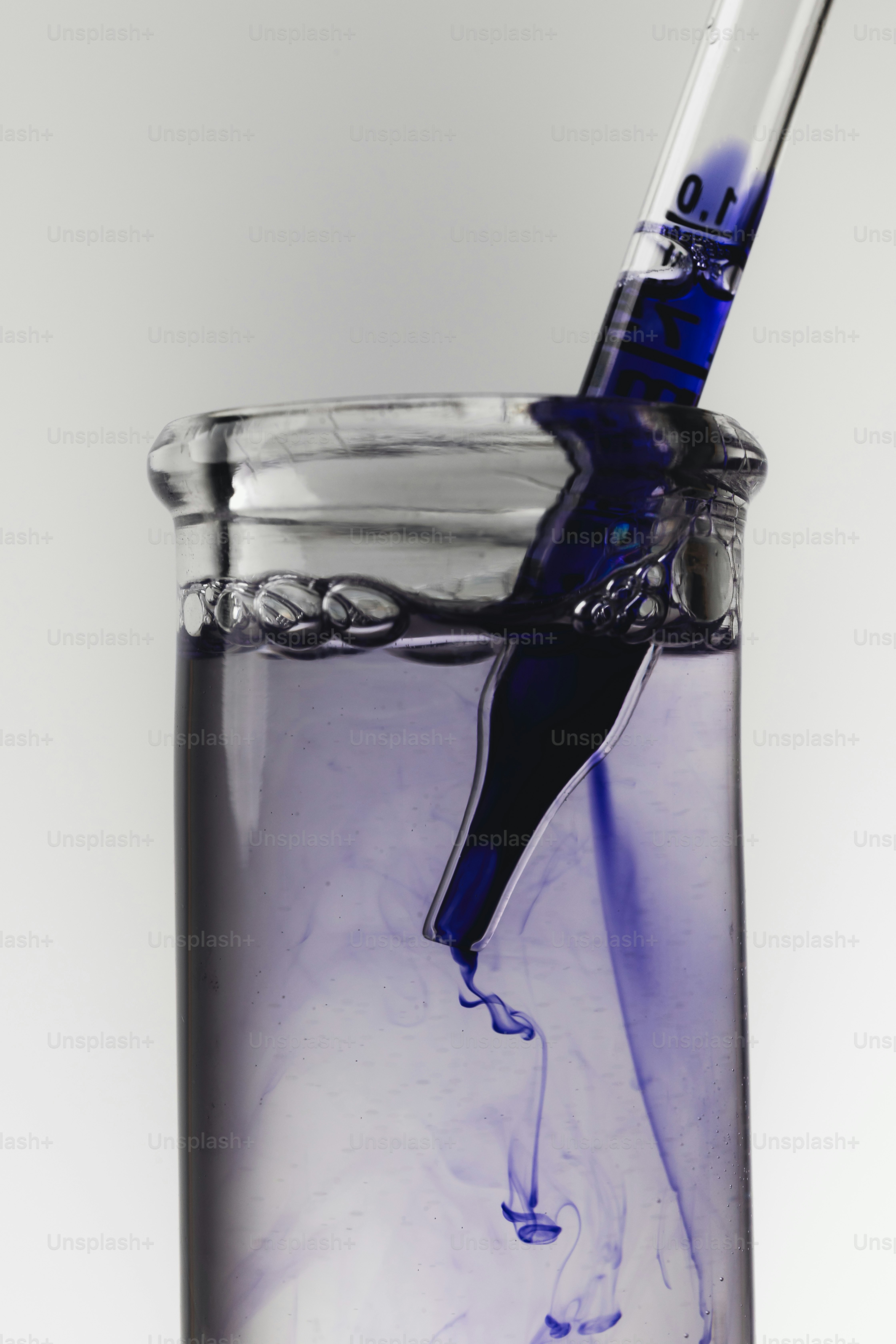 Dropper adding blue liquid to test tube