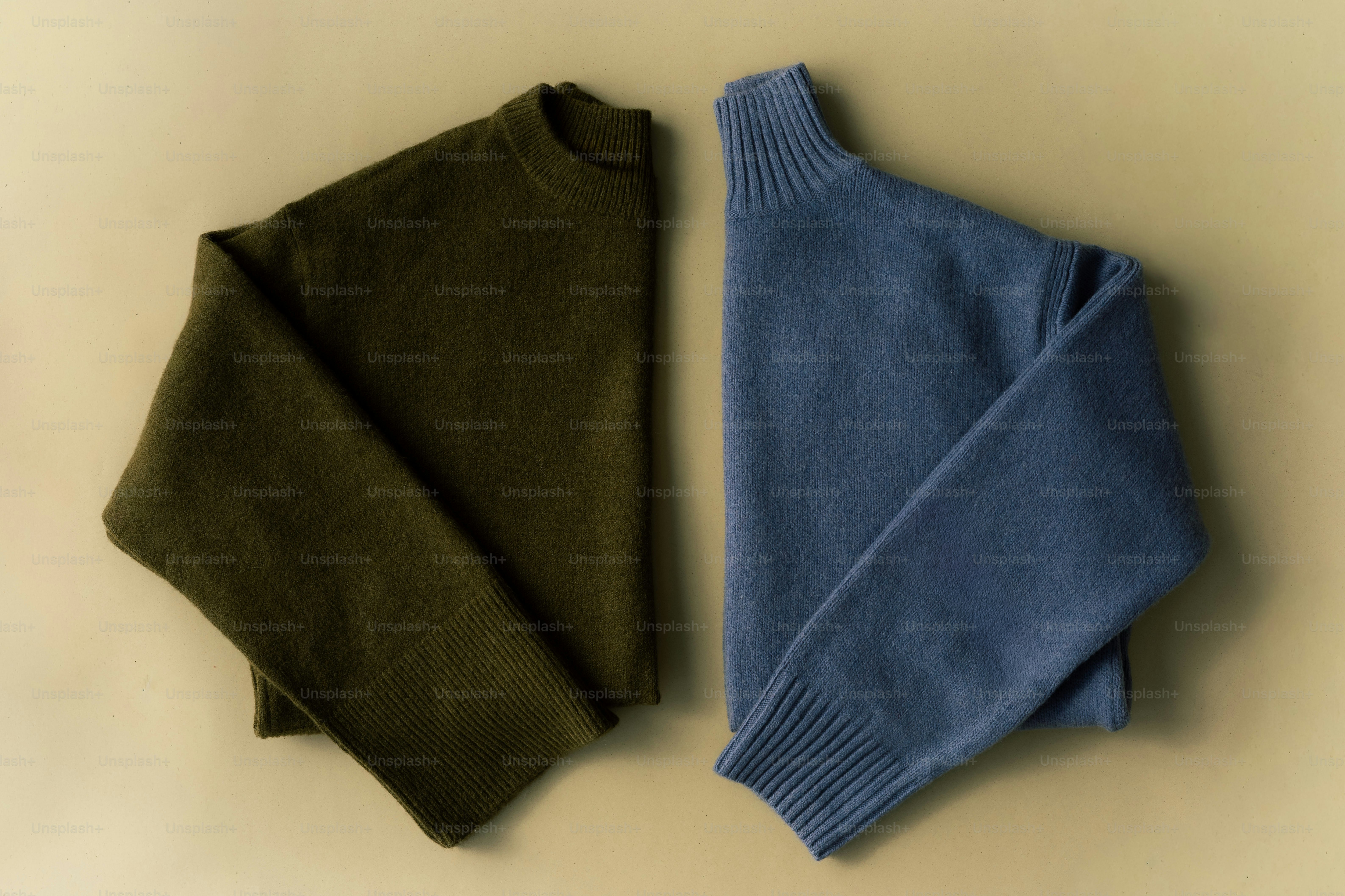 Dua sweater dilipat, satu hijau zaitun, satu biru