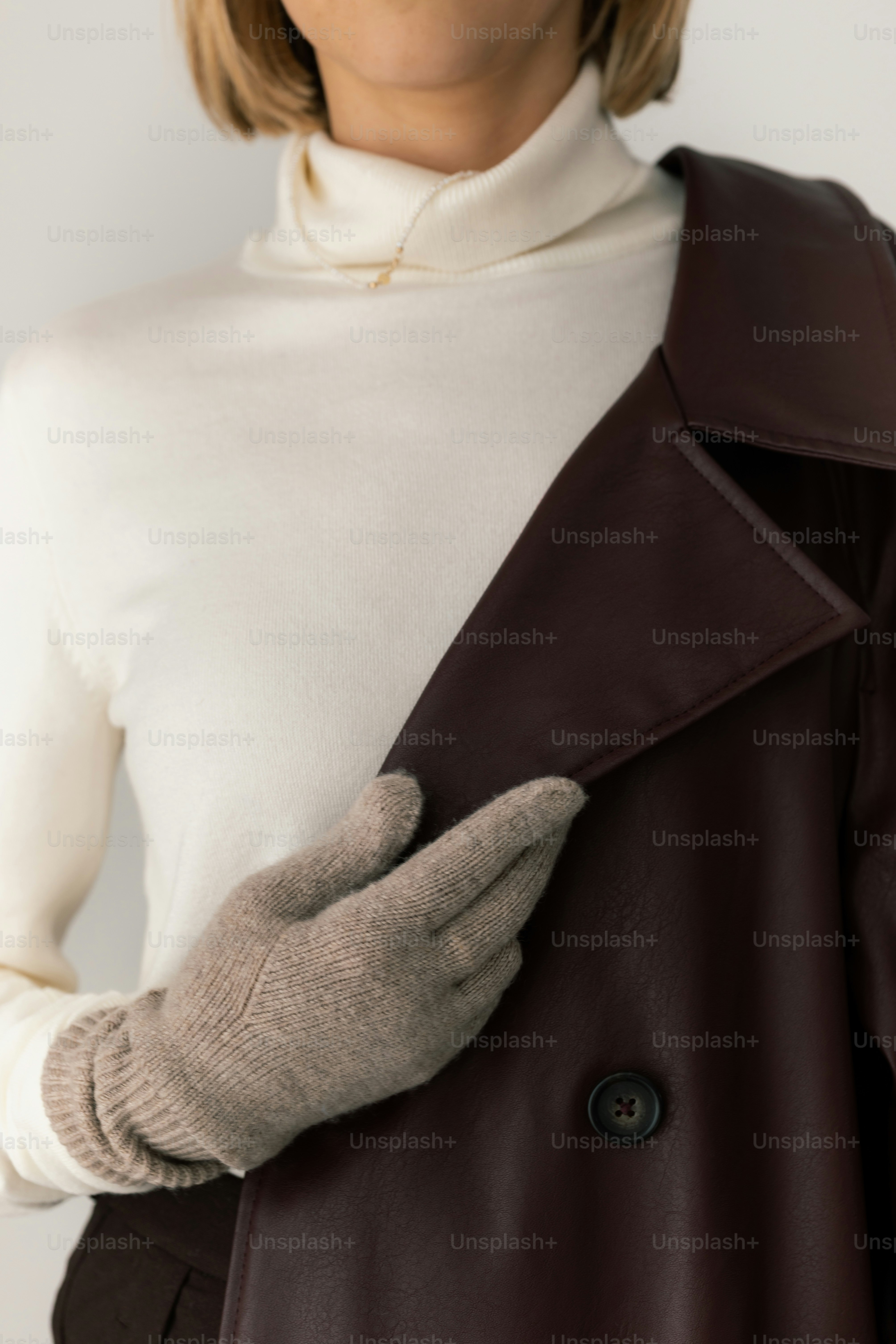 Woman in turtleneck and gloves holding coat
