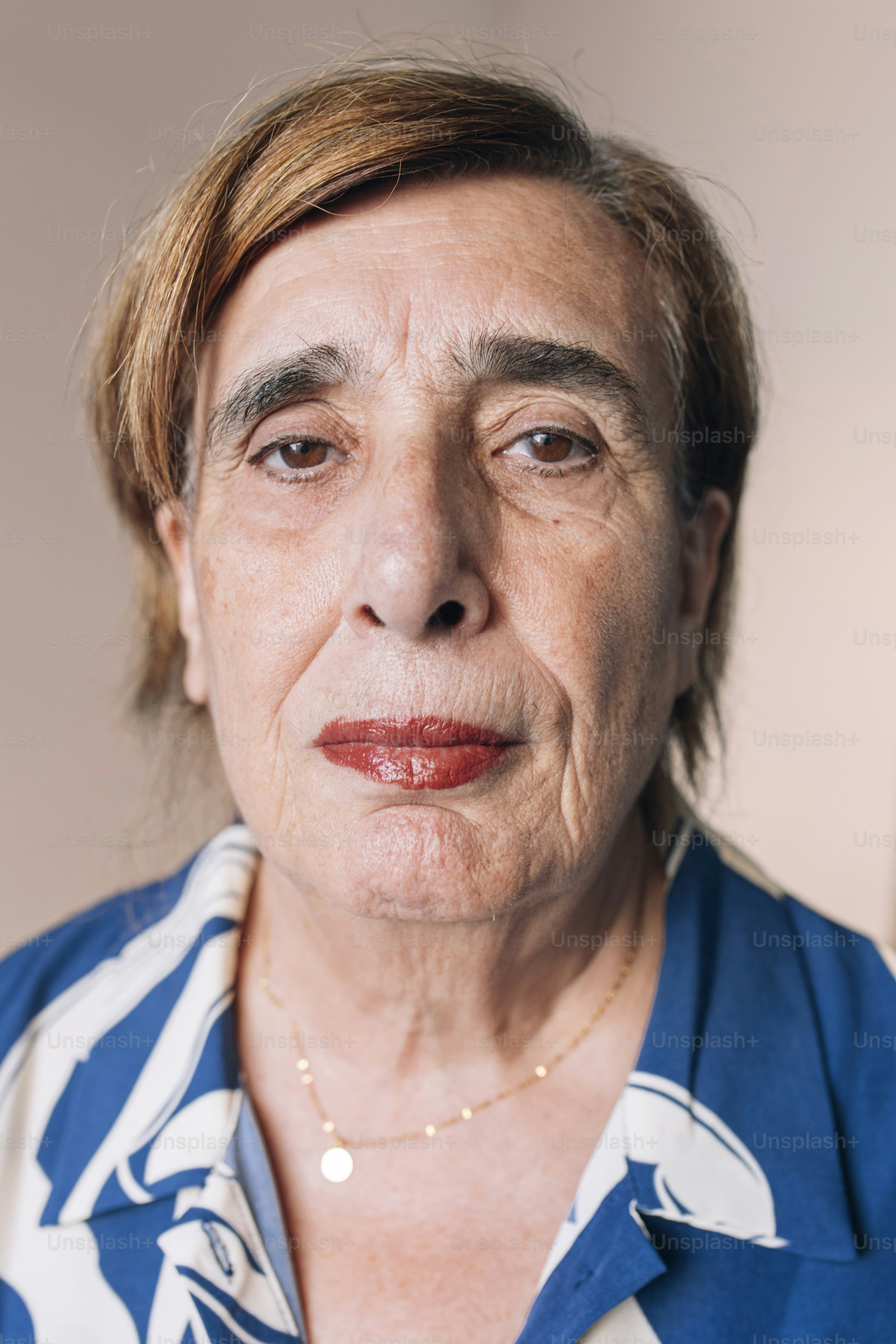 Ältere Frau mit kurzen braunen Haaren und Make-up.