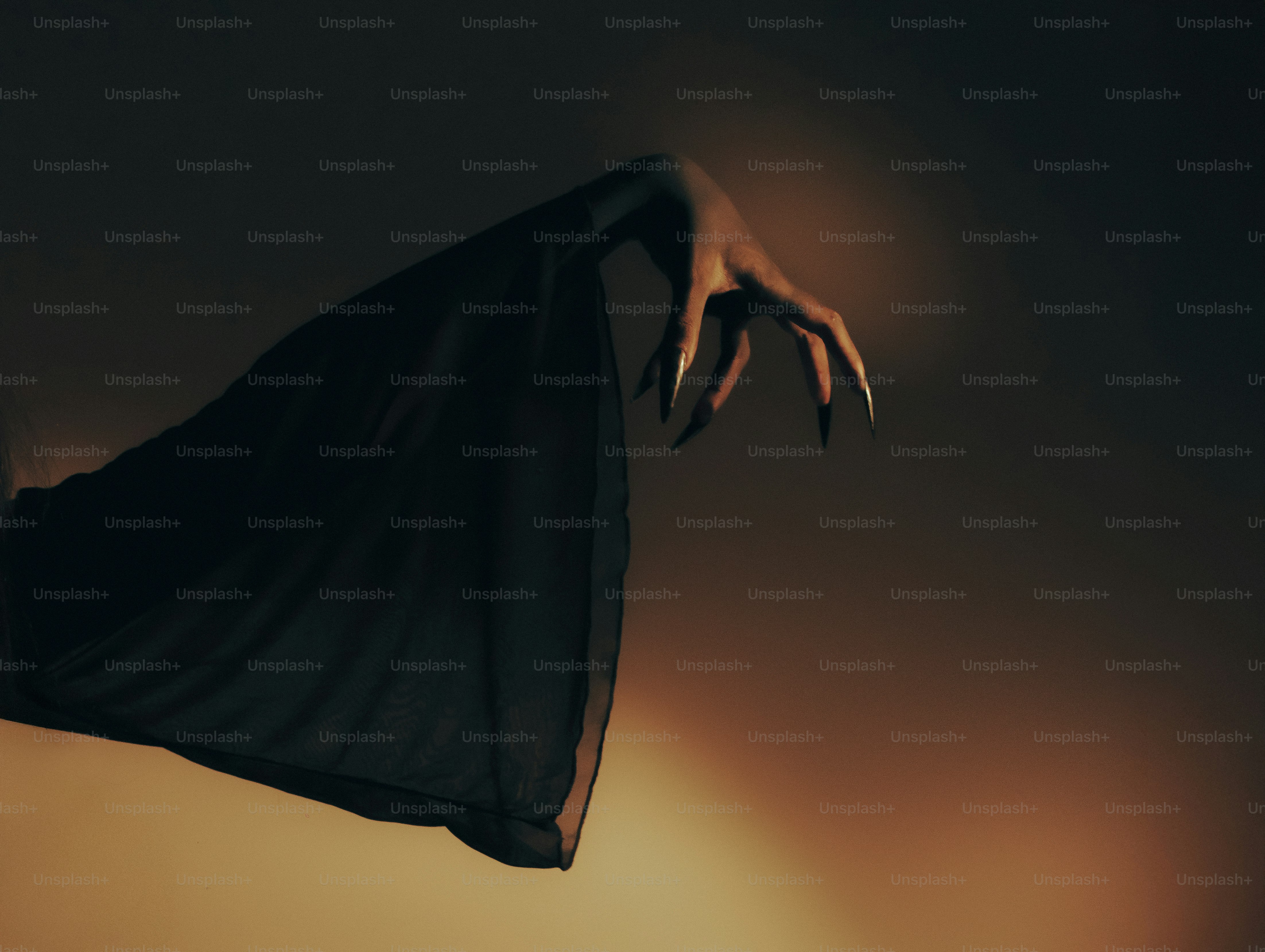 A dark, skeletal hand with long claws emerges from fabric. photo – Dark ...