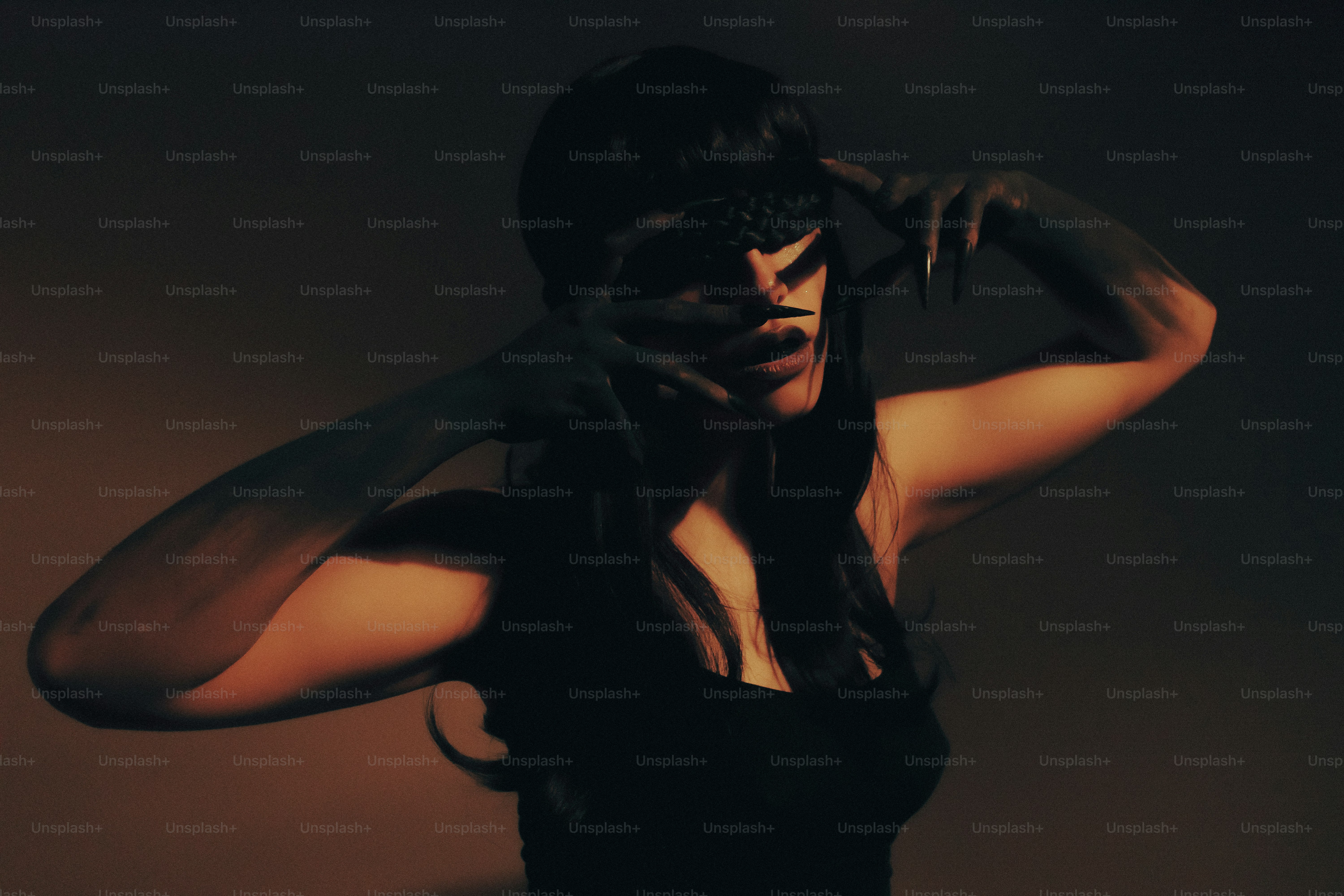 Donna con i capelli scuri e le mani che coprono il viso