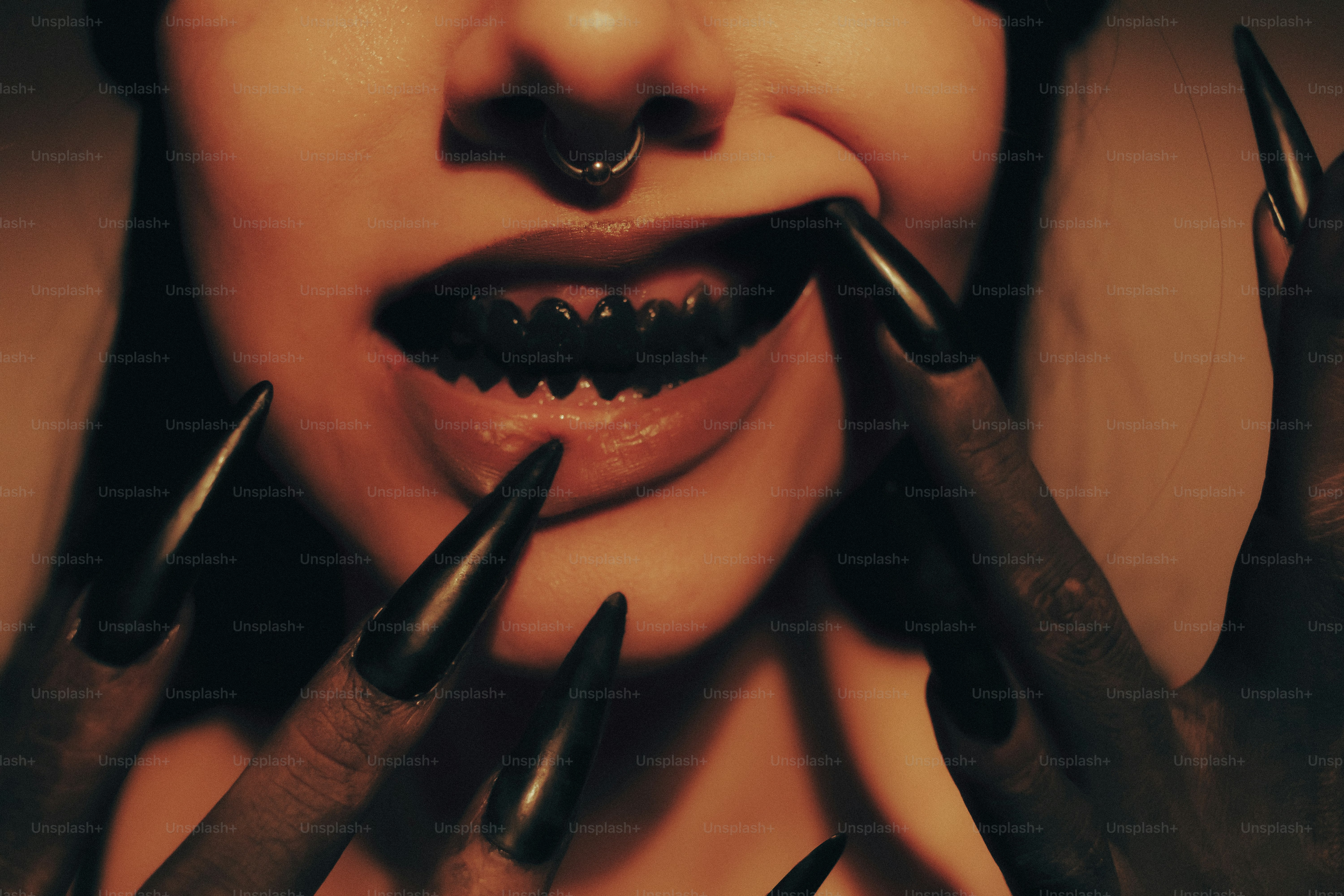 Woman with sharp black nails and dark teeth