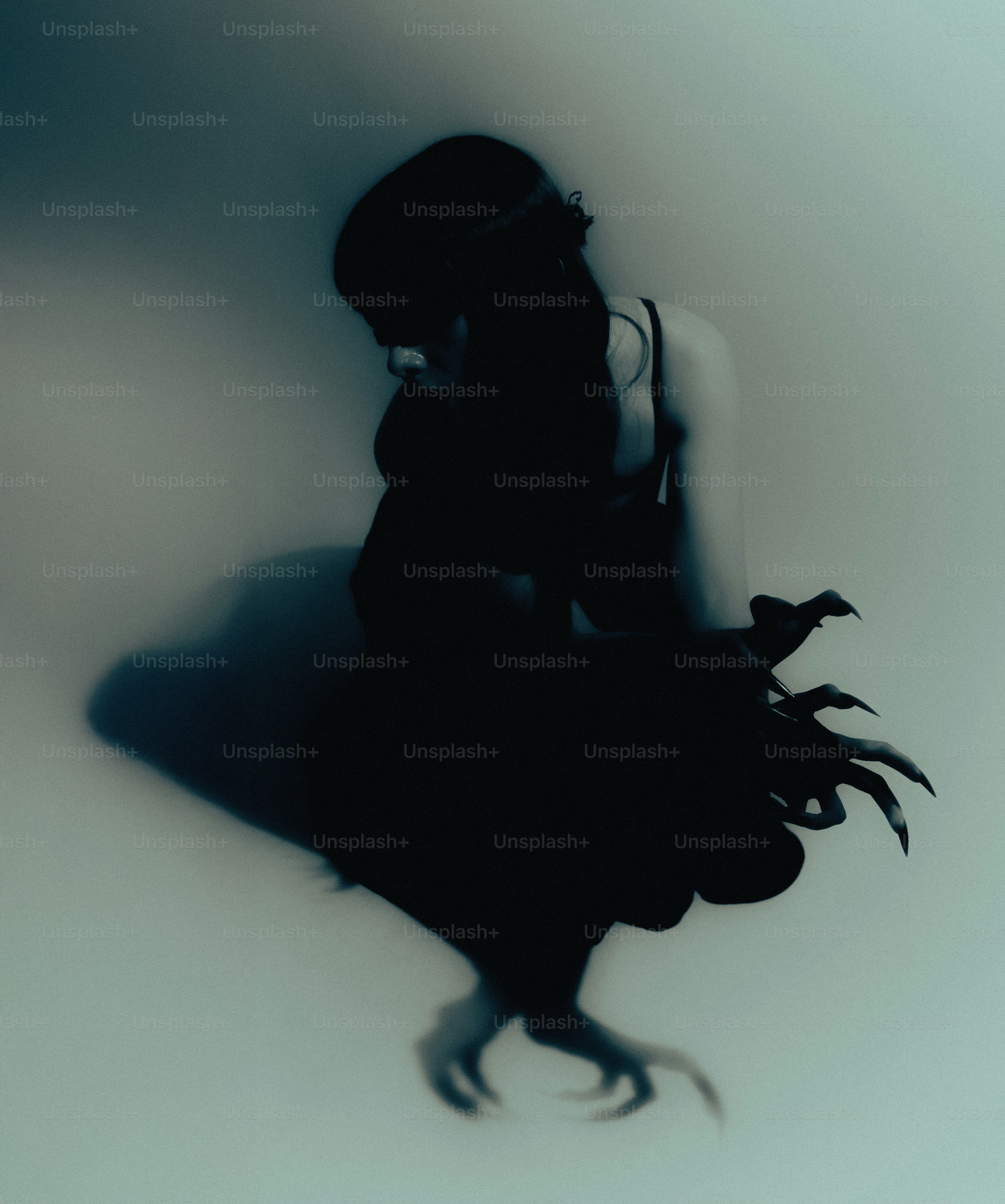 Silhouette of a woman with long, sharp fingernails