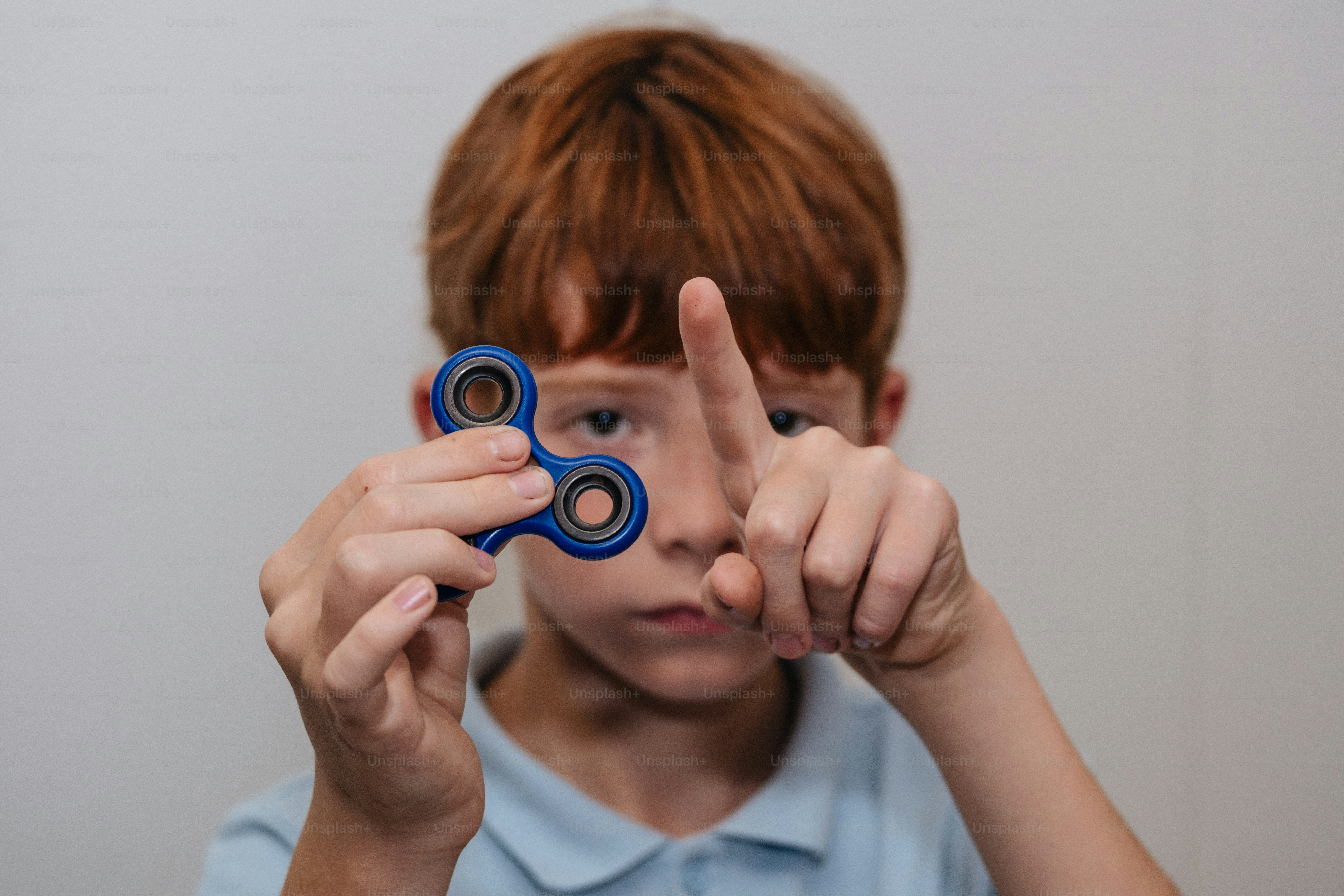 Garçon tenant un jouet bleu fidget spinner.