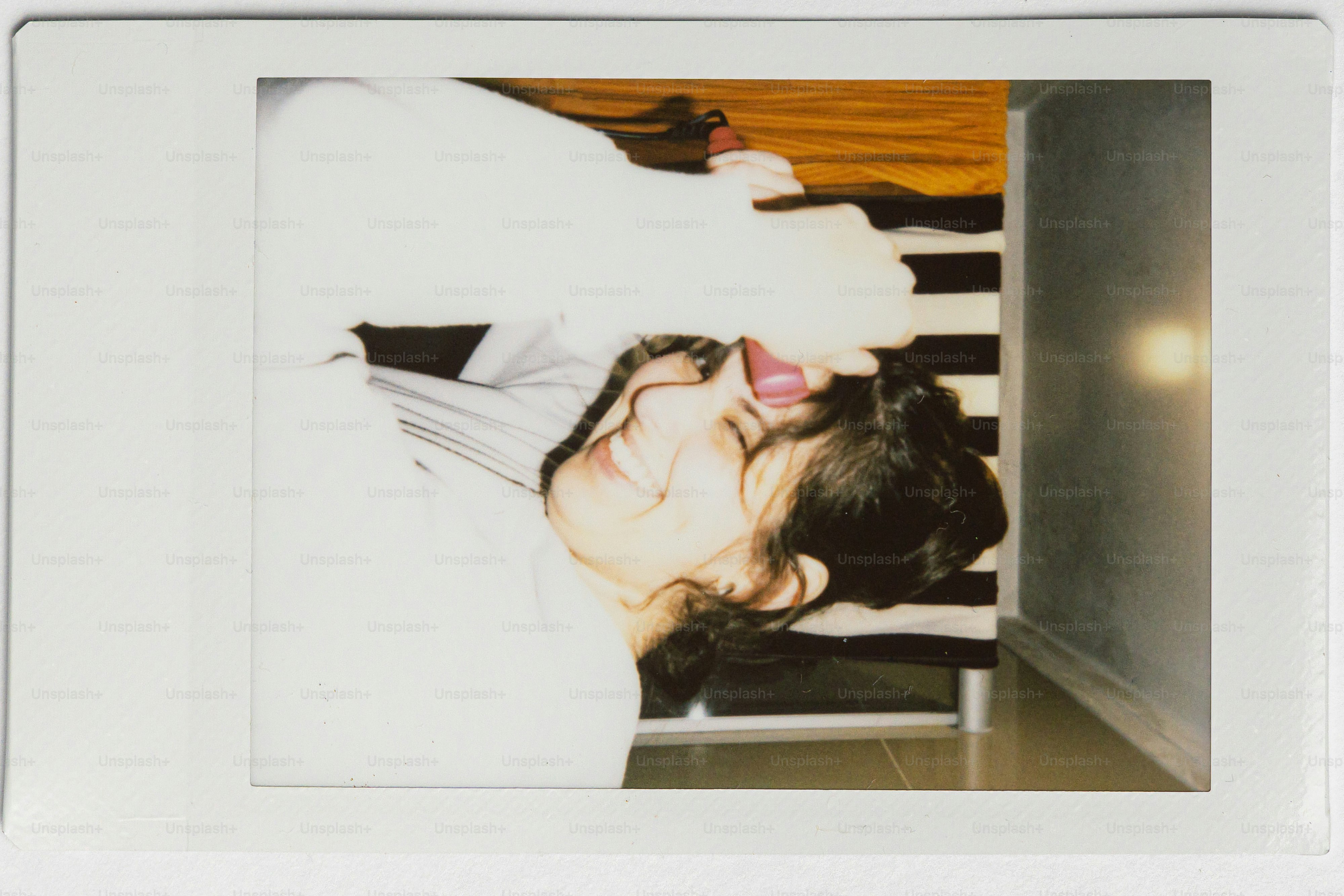 A young woman with dark hair laughs joyfully.