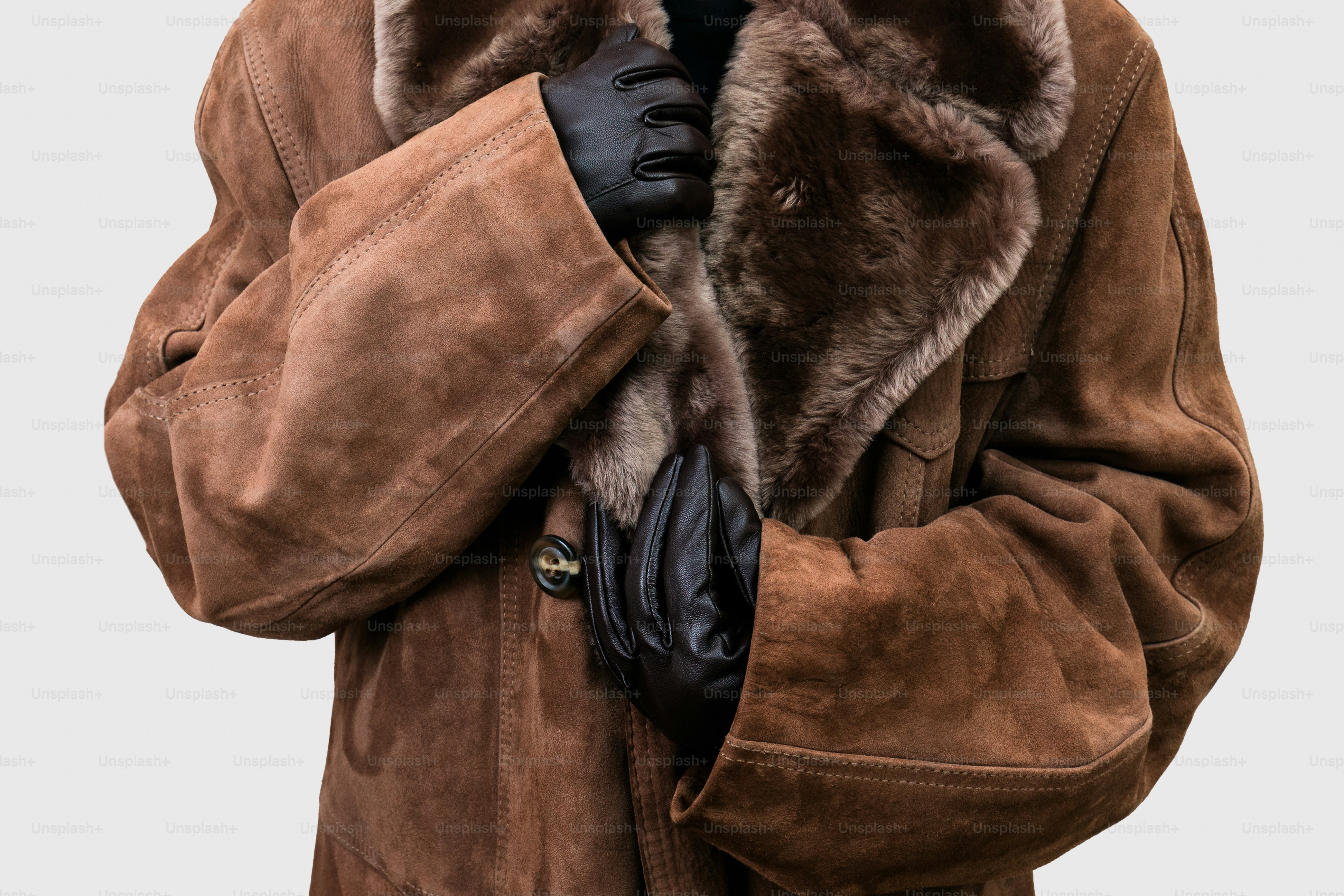 Person wearing a brown suede coat with fur collar.