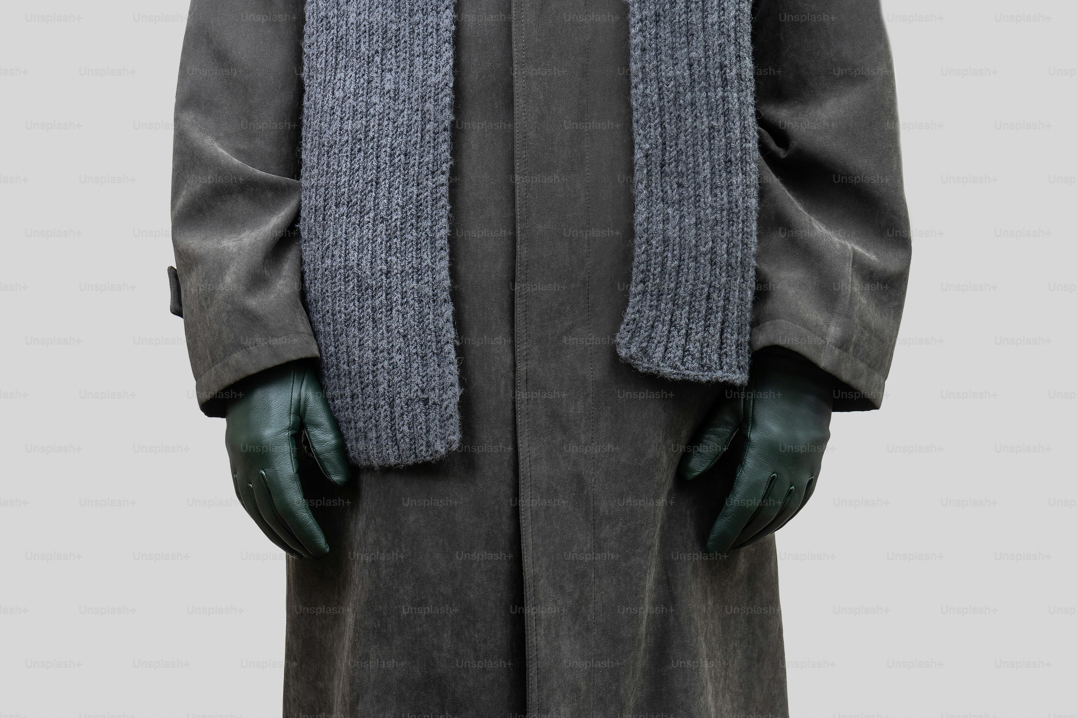 Person wearing a trench coat, scarf, and gloves