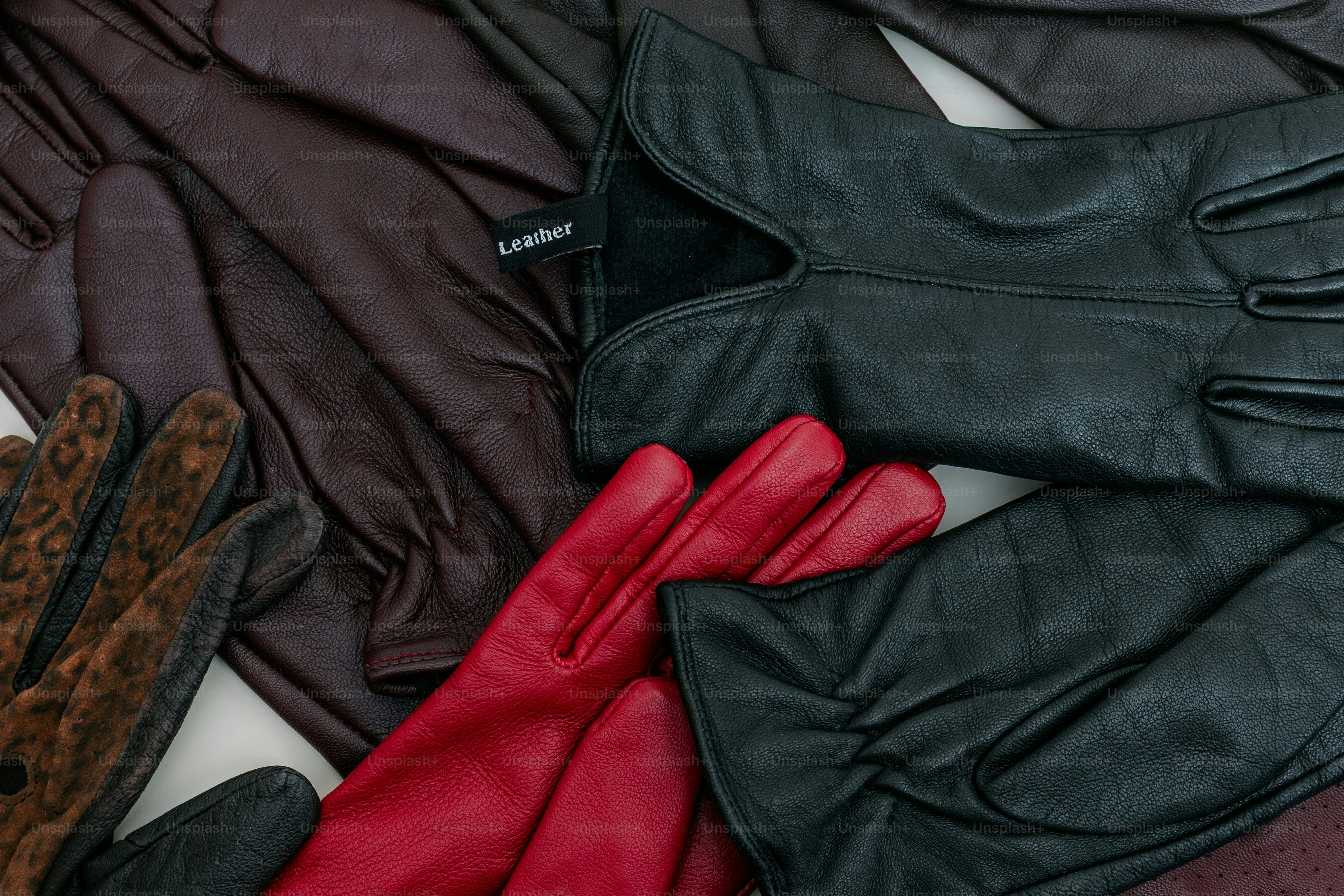Pile of assorted leather gloves in various colors.