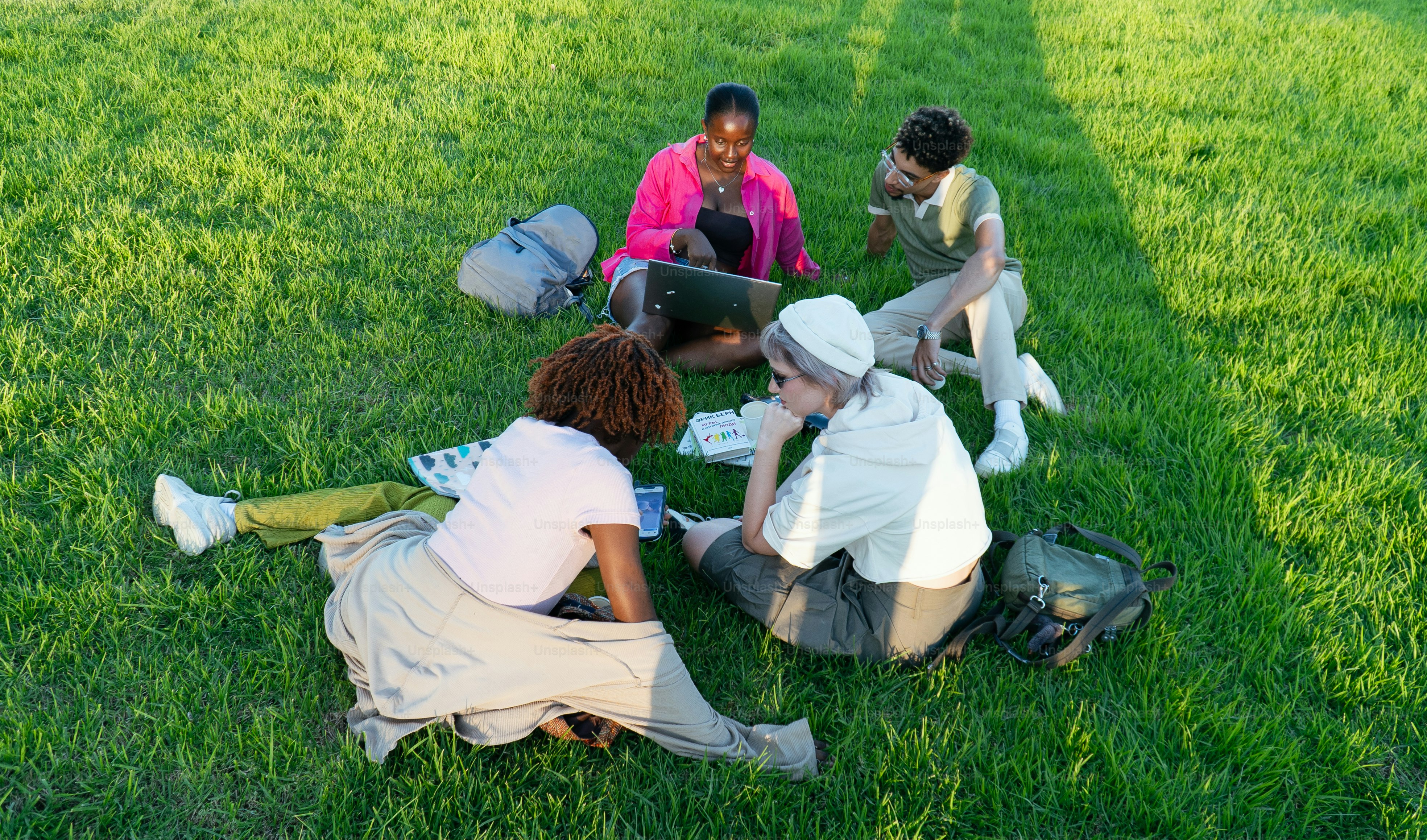 Four friends sitting in a circle on grass photo  Technology Image on  Unsplash