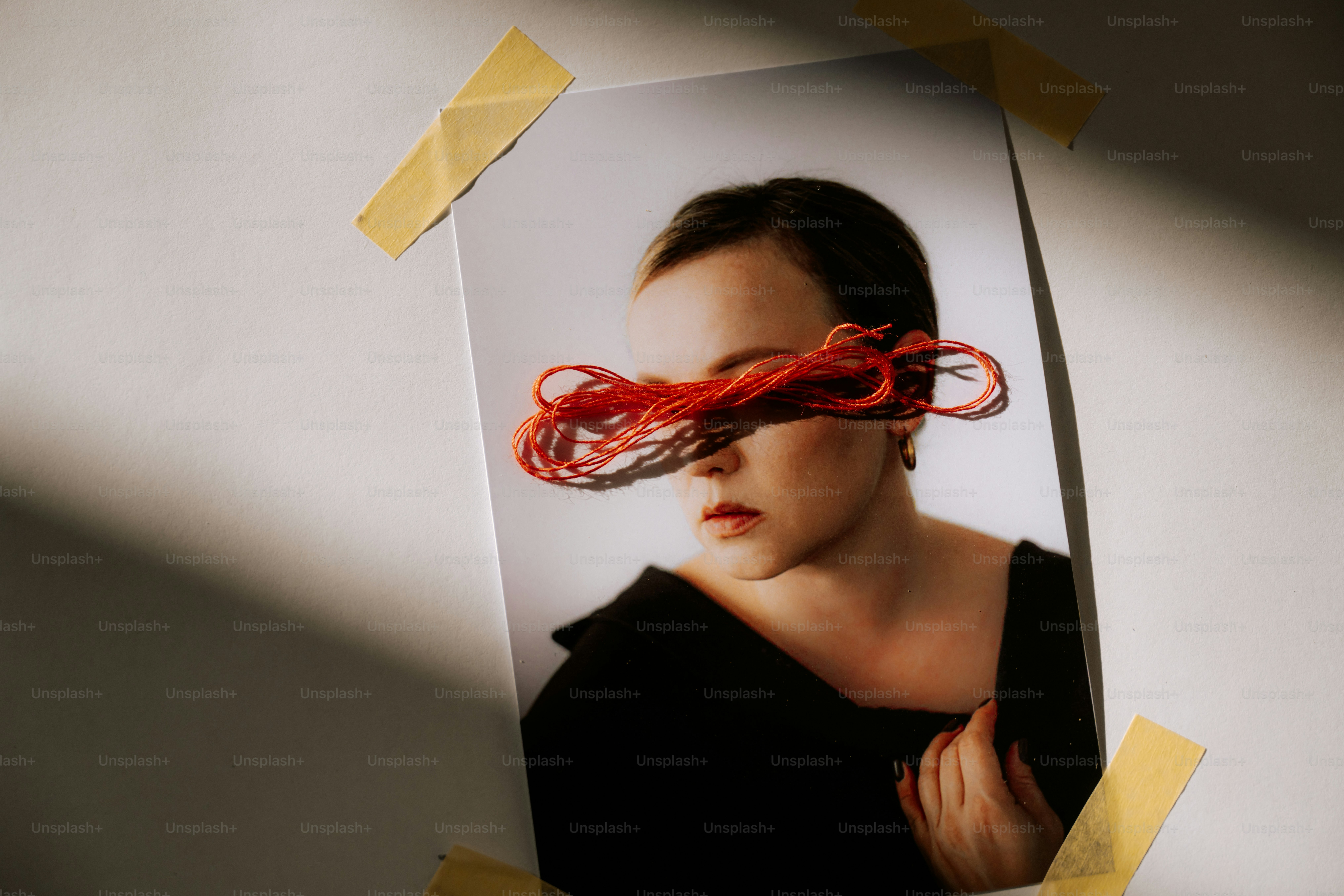 Mulher com fio vermelho cobrindo os olhos em uma impressão