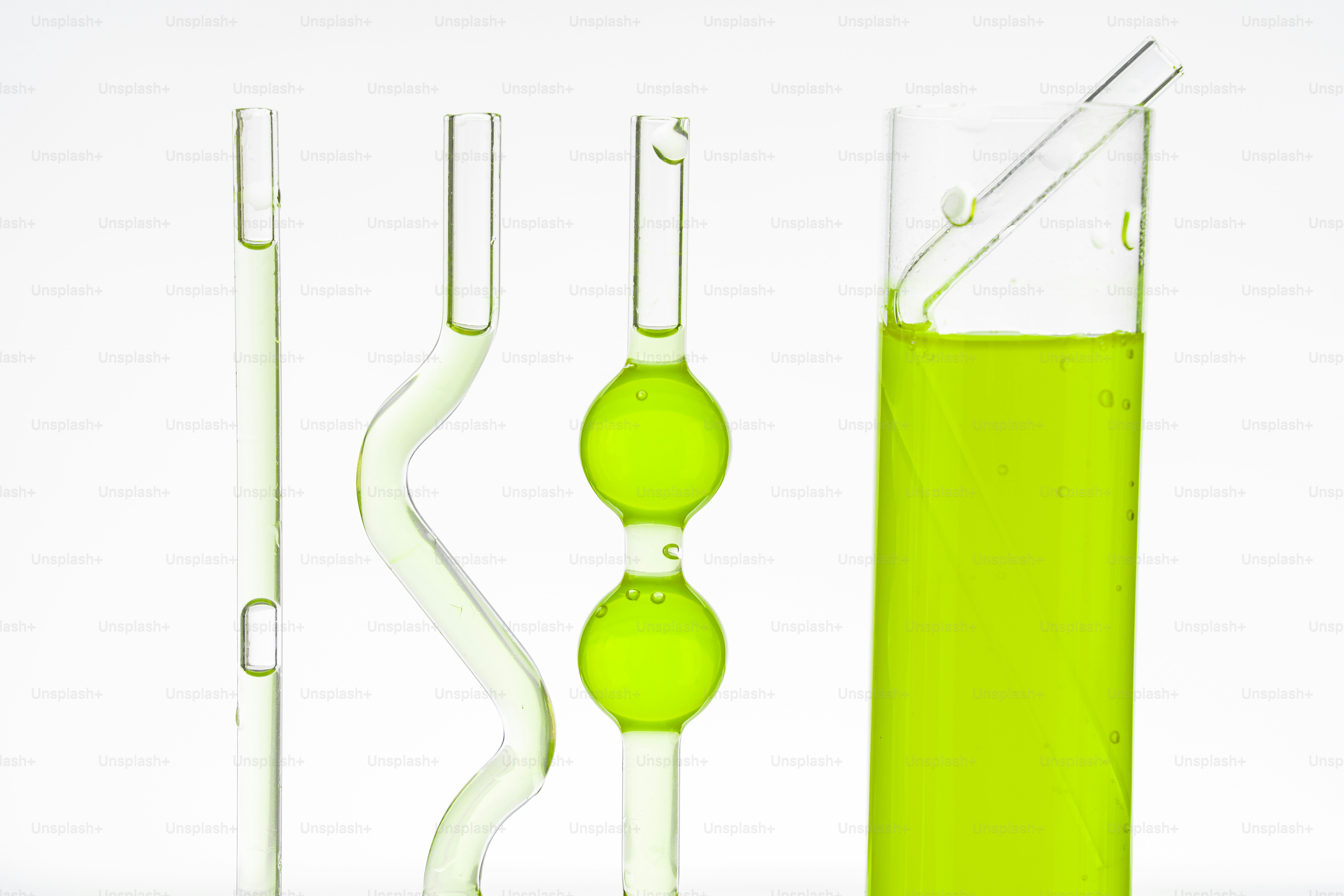 Four glass tubes with green liquid